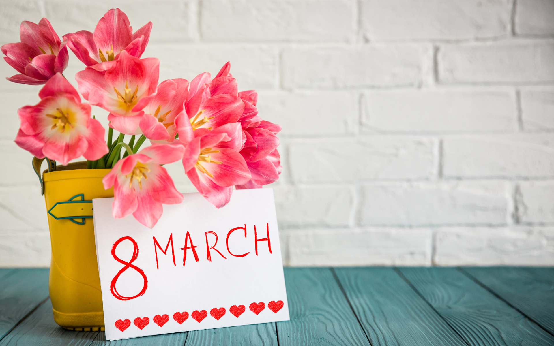 Букет тюльпанов и открытка на фоне стены на 8 марта