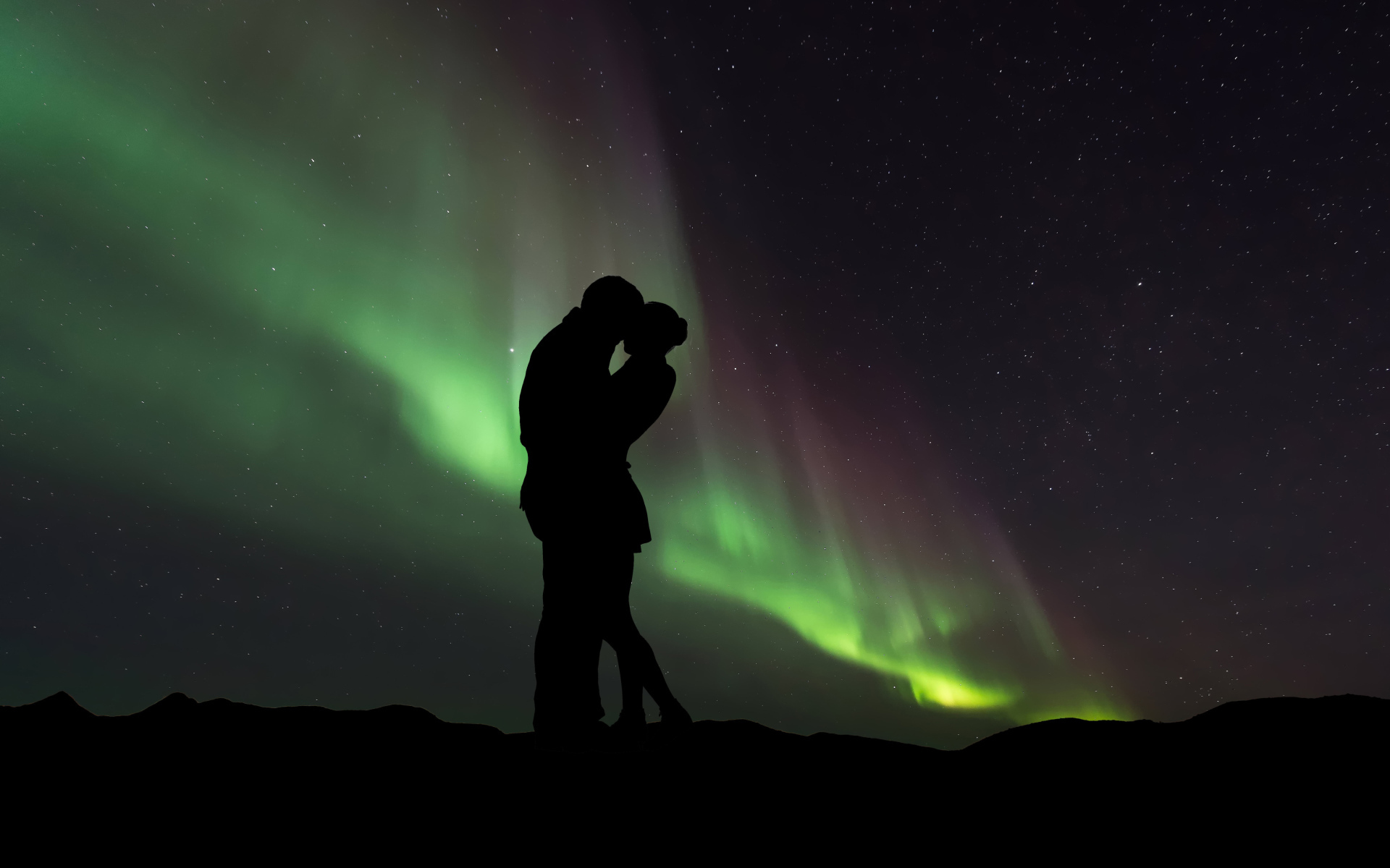 Силуэт влюбленной пары на фоне северного сияния 