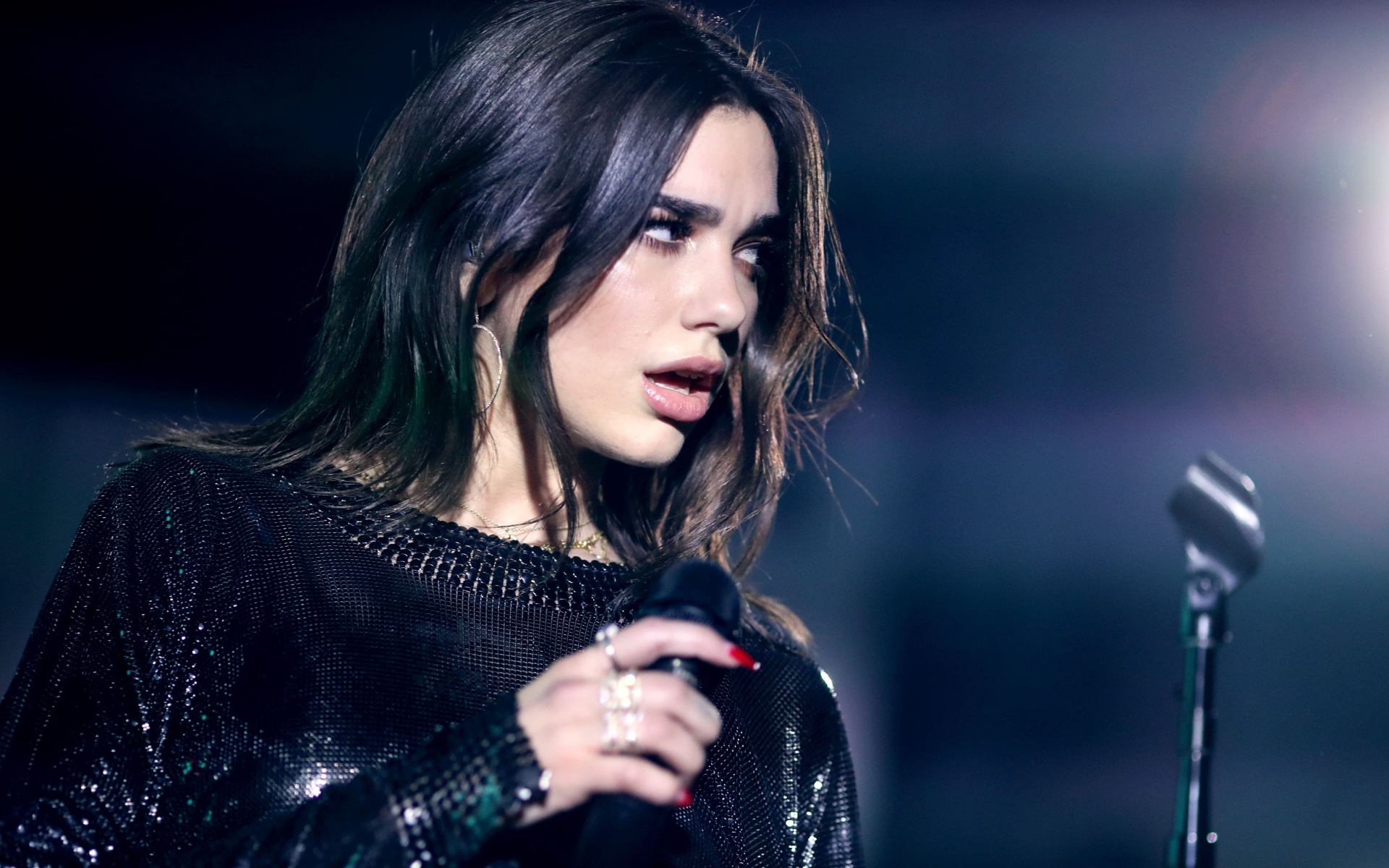 Британская певица Дуа Липа с микрофоном в руках