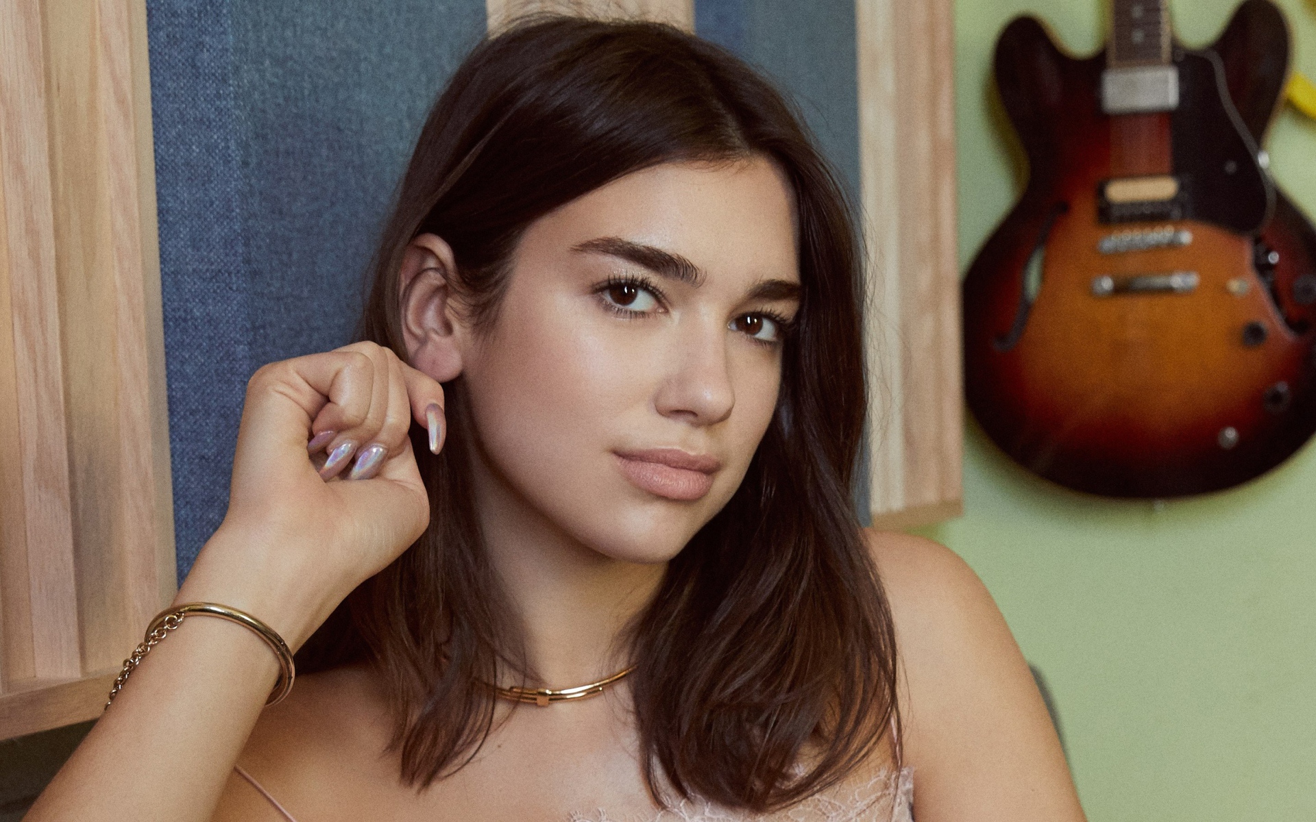 Певица Дуа Липа с гитарой на стене