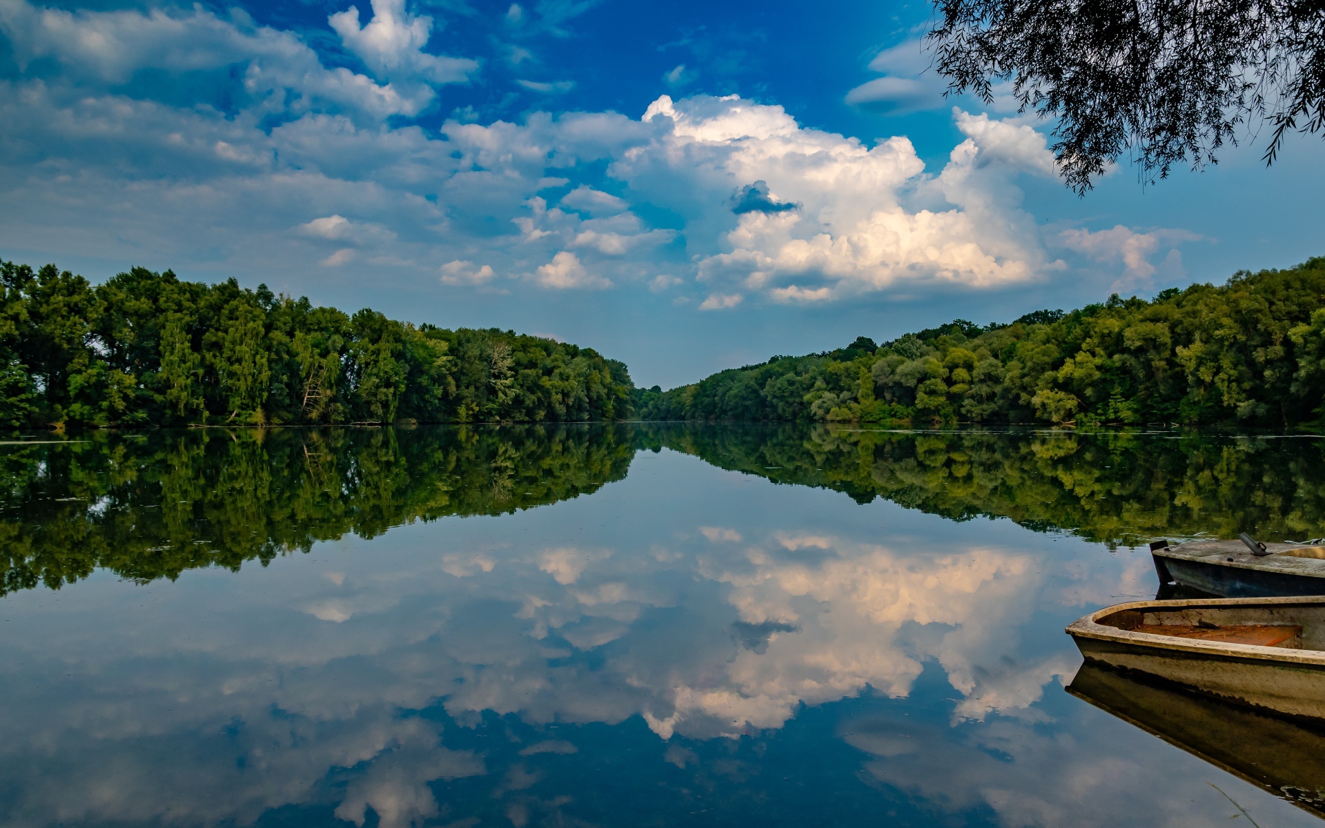 Beautiful blue sky and green forest reflected in the mirror of the lake
