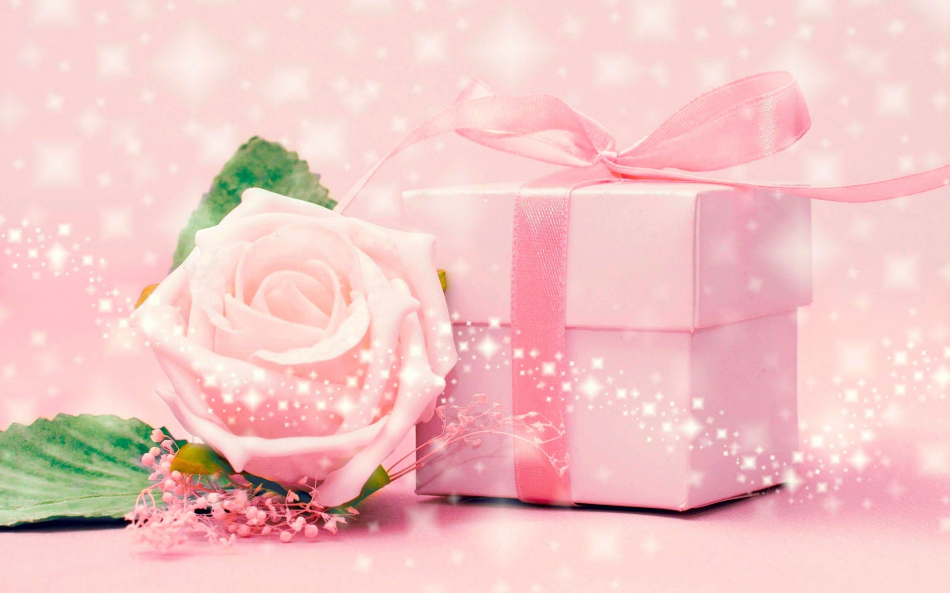 Розовая коробка с подарком и розовой розой 