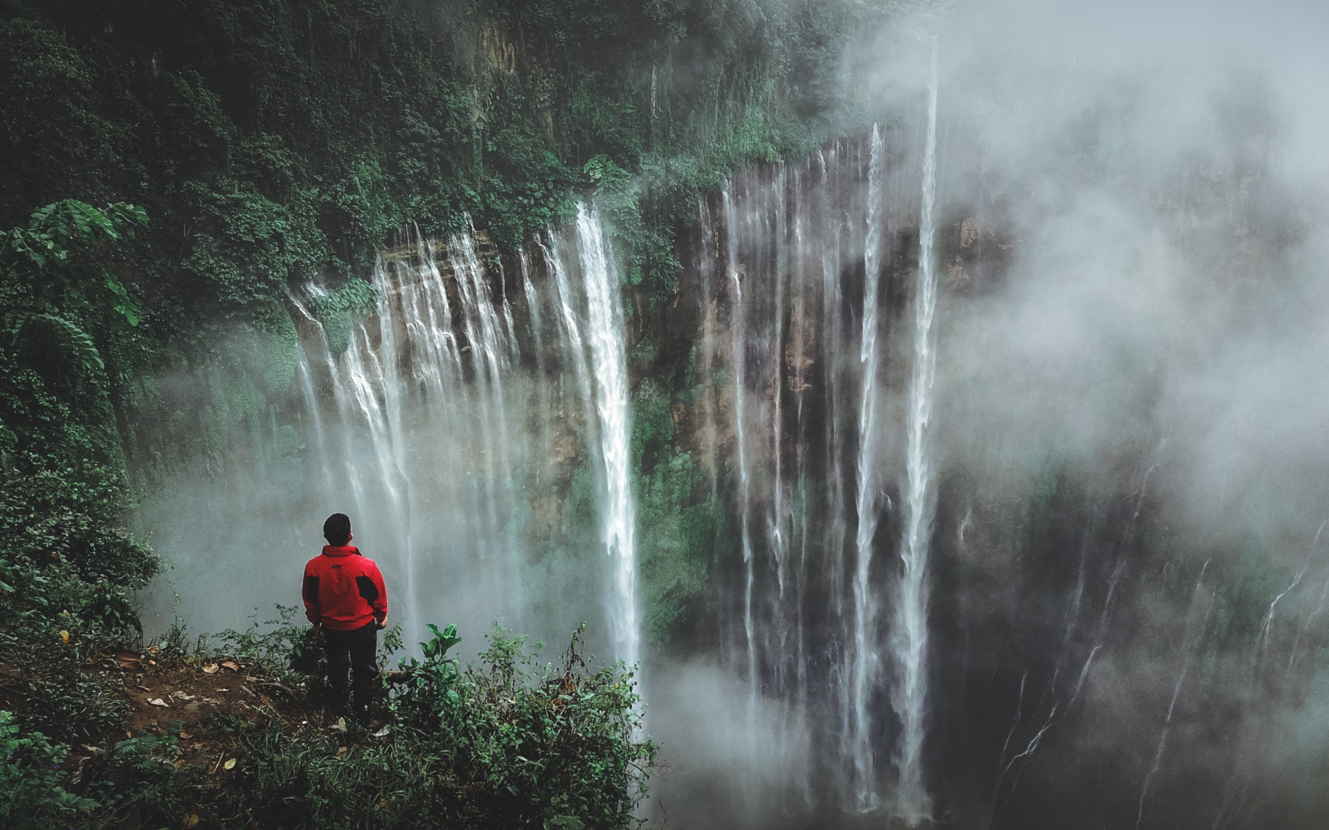 Человек смотрит на водопад сверху. 