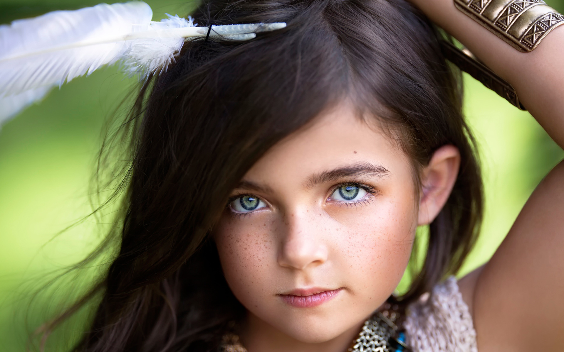 Маленькая красивая девочка с белым пером в волосах