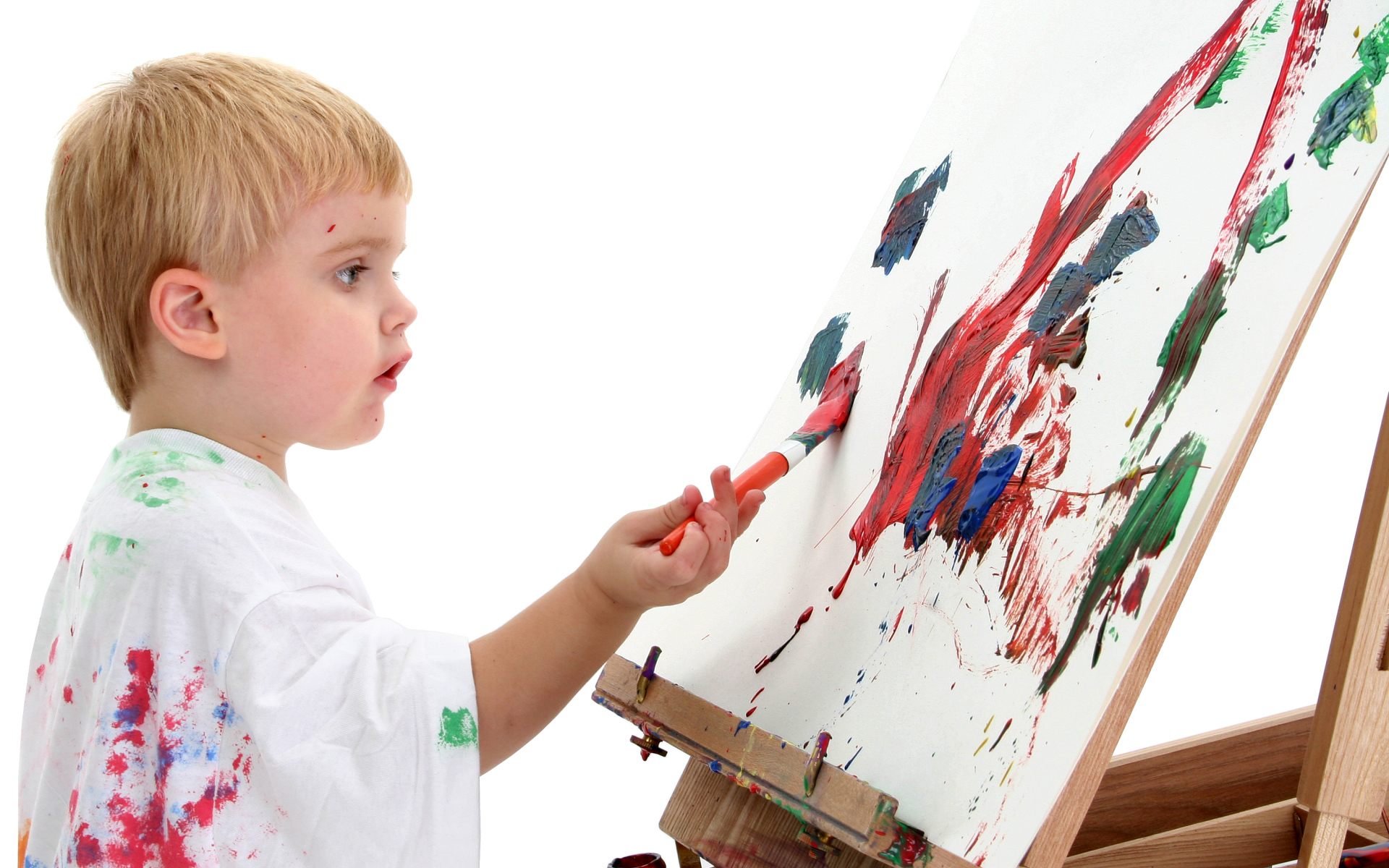 Маленький мальчик рисует красками 