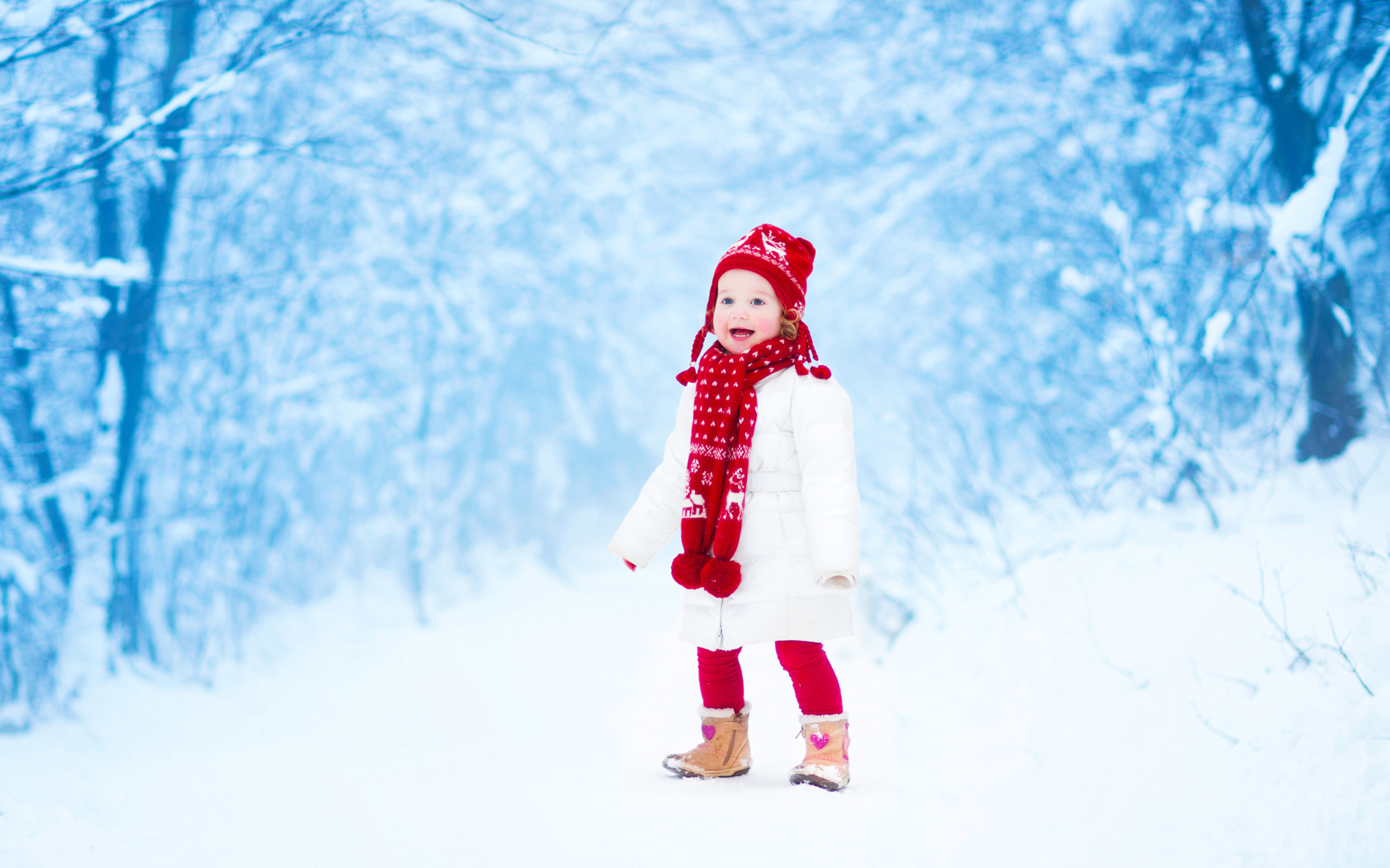 Маленькая веселая девочка в зимнем лесу