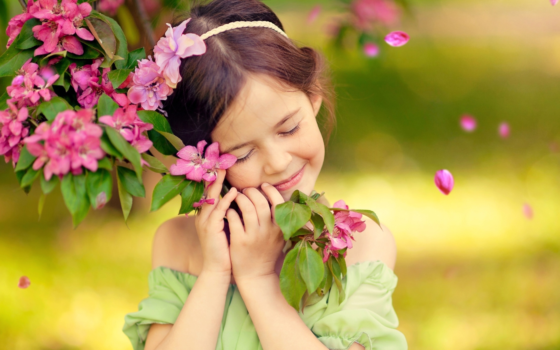 Маленькая девочка обнимает ветку с розовыми цветами