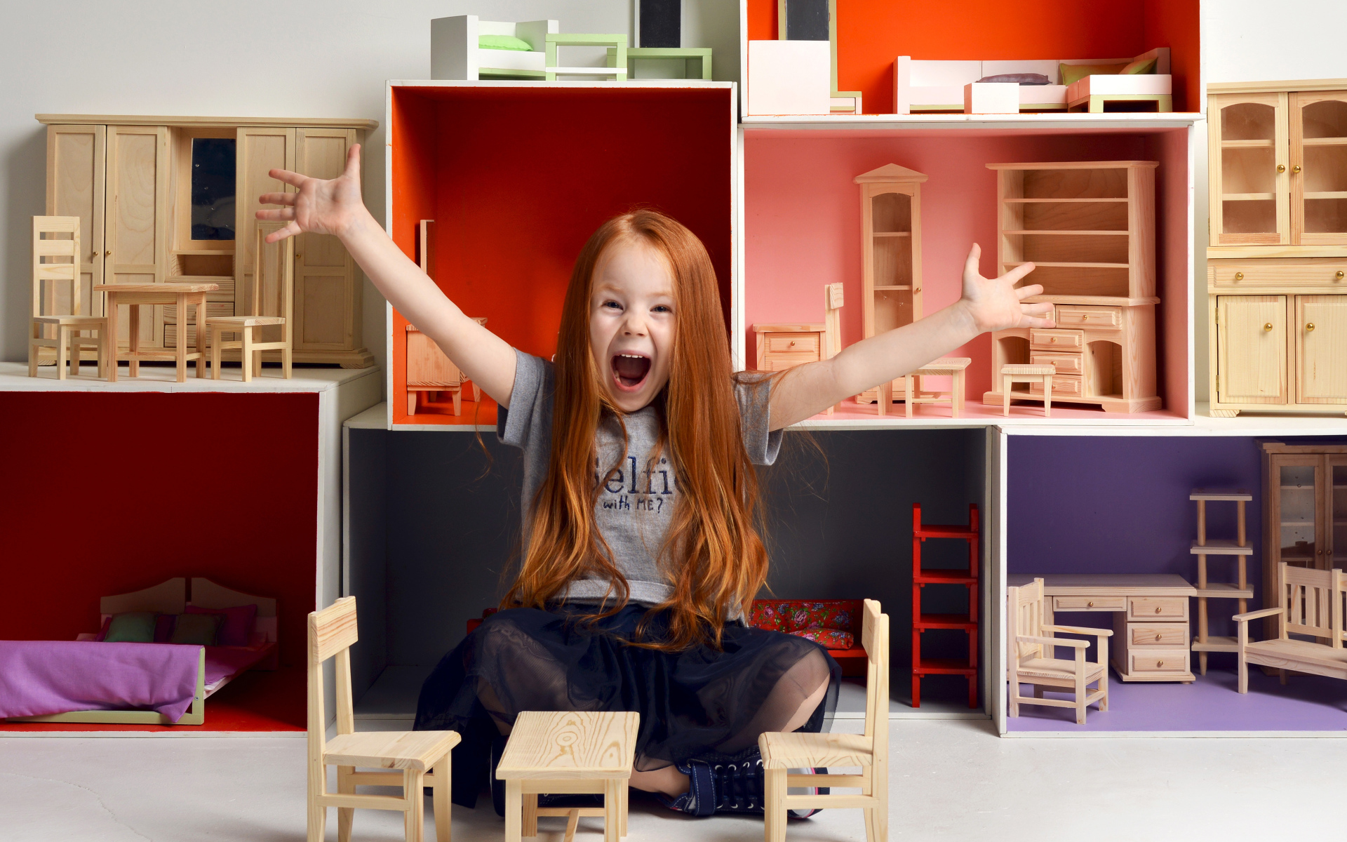 Маленькая девочка с игрушечной мебелью