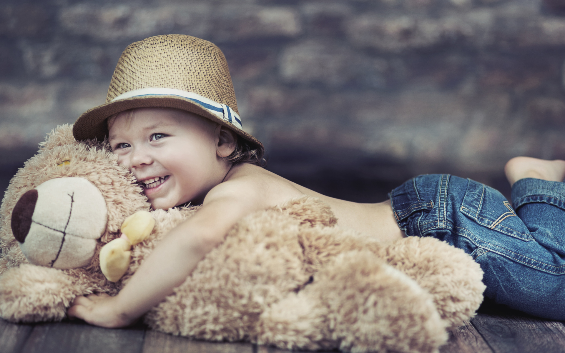 Улыбающийся мальчик обнимает игрушку