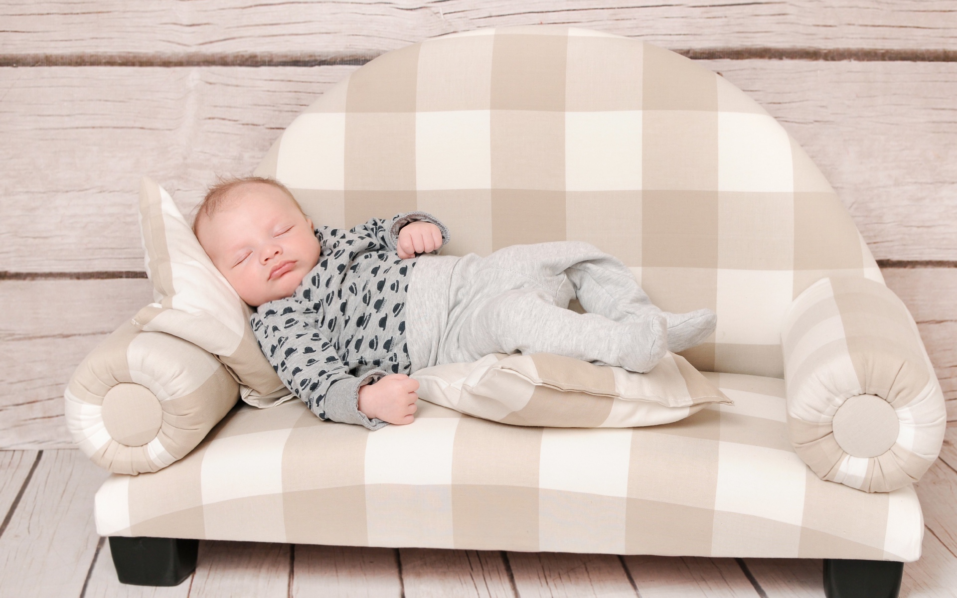Грудной ребенок спит на диване