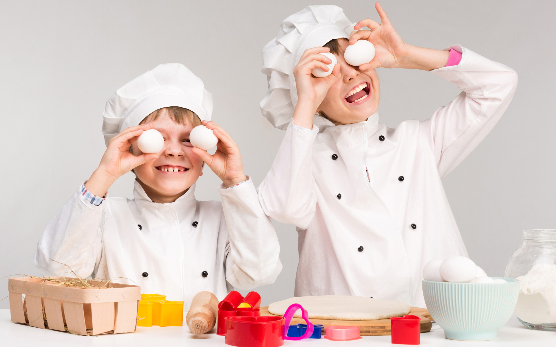 Два маленьких мальчиках в костюмах повара на кухне