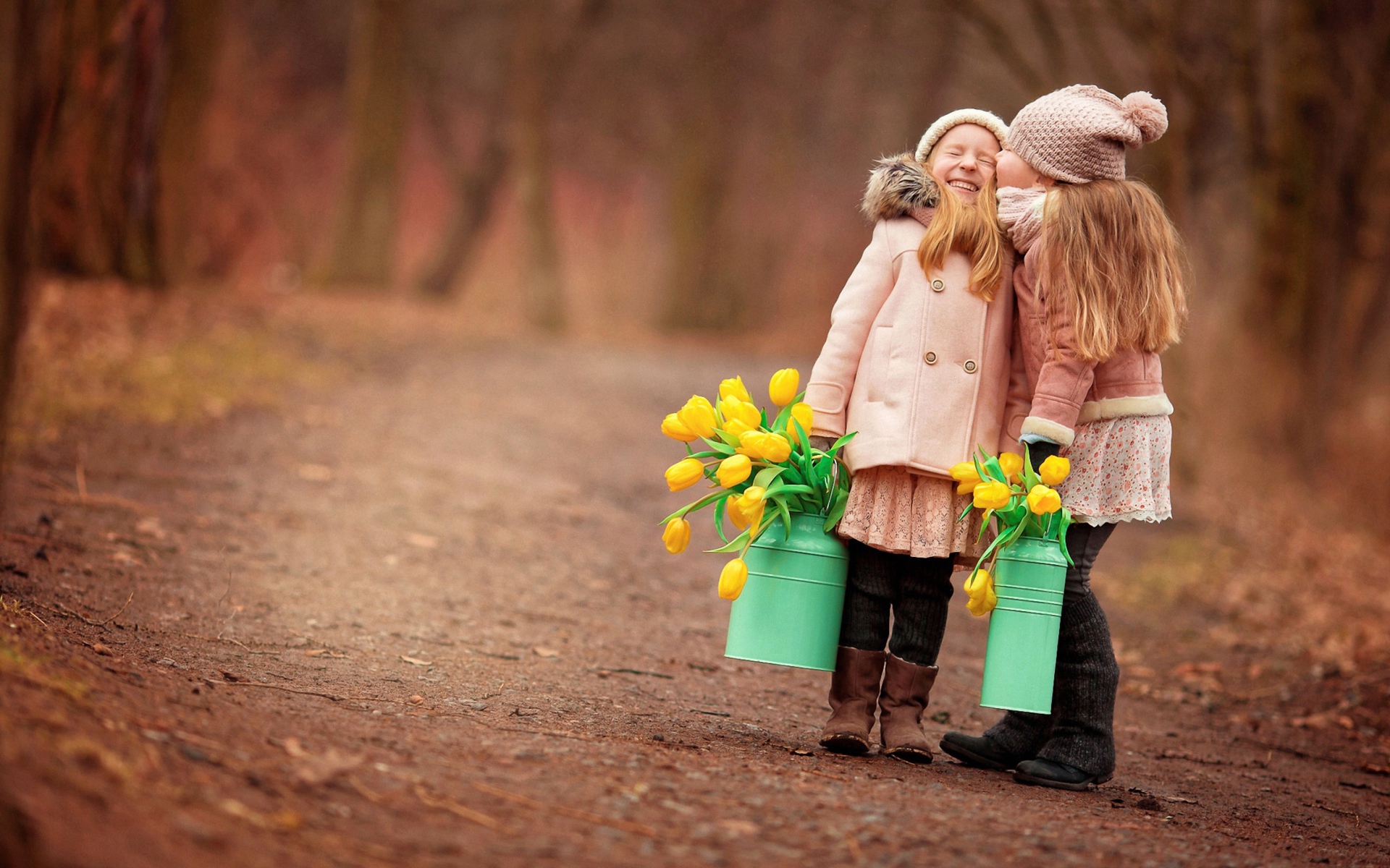 Две маленькие девочки с желтыми тюльпанами весной