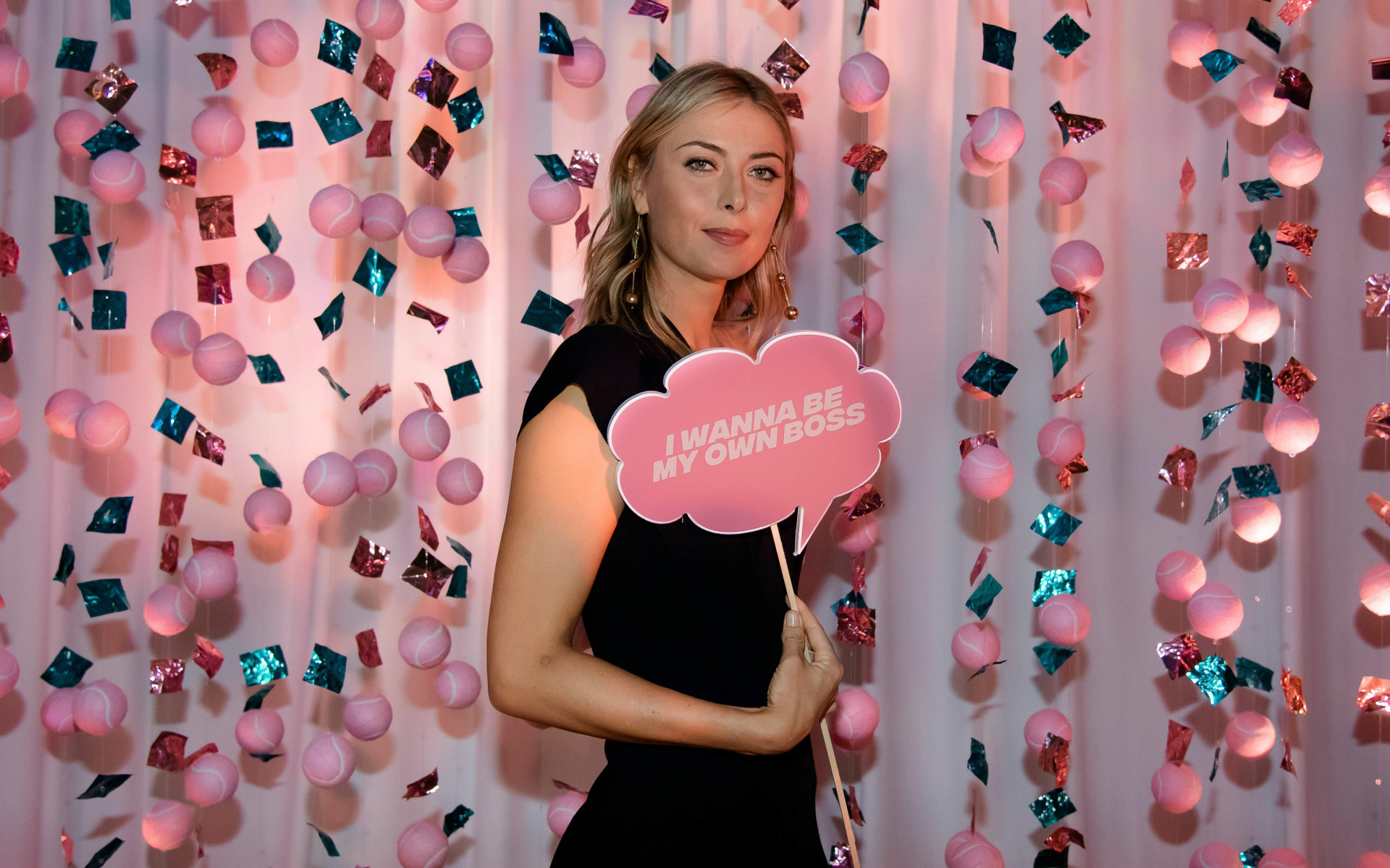 Теннисистка Мария Шарапова с табличкой в руках на розовом фоне