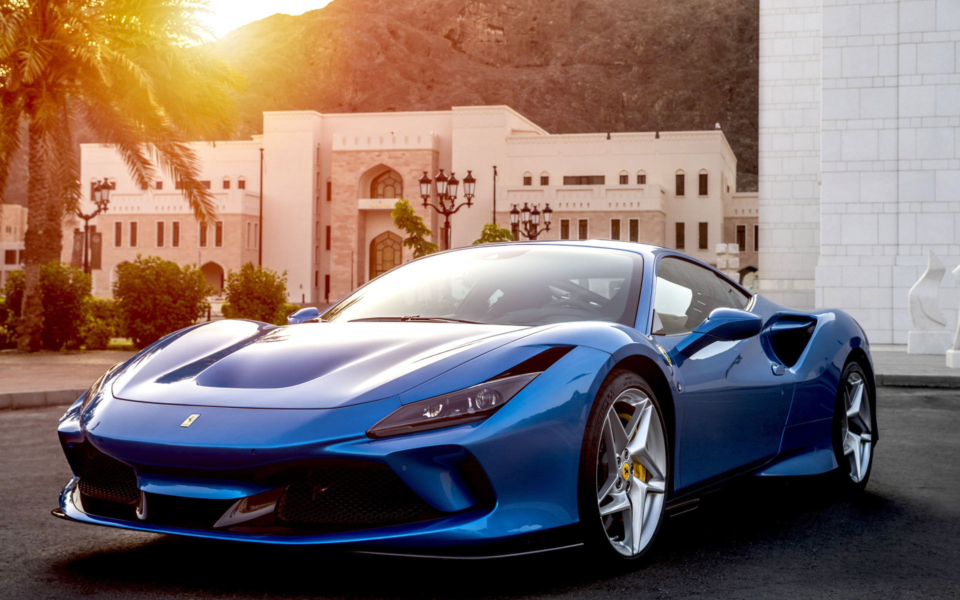 Голубой спортивный автомобиль Ferrari F8 Tributo 2019 года на фоне здания
