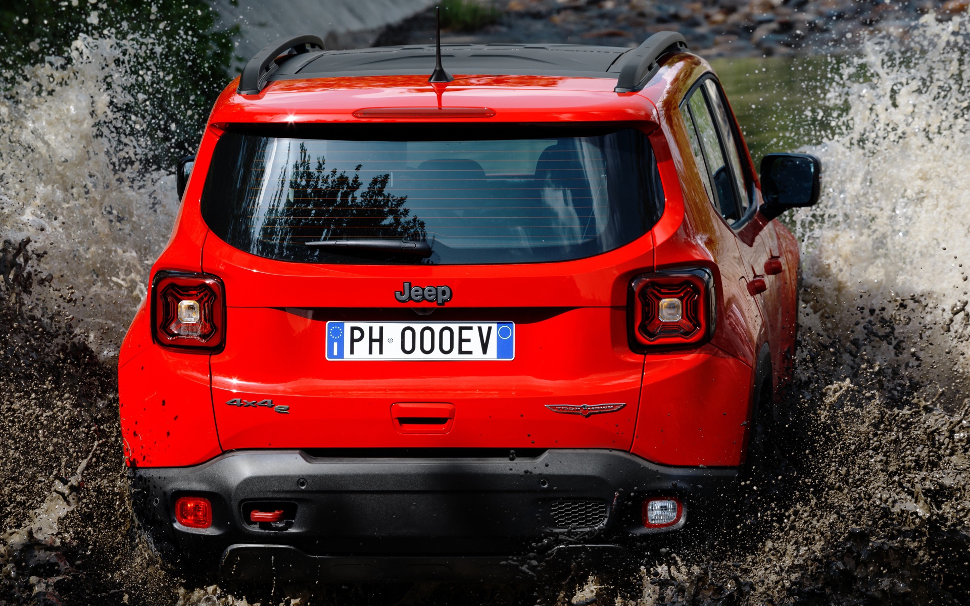 Красный Jeep Renegade Trailhawk Plug-In Hybrid, 2019 года едет по воде вид сзади