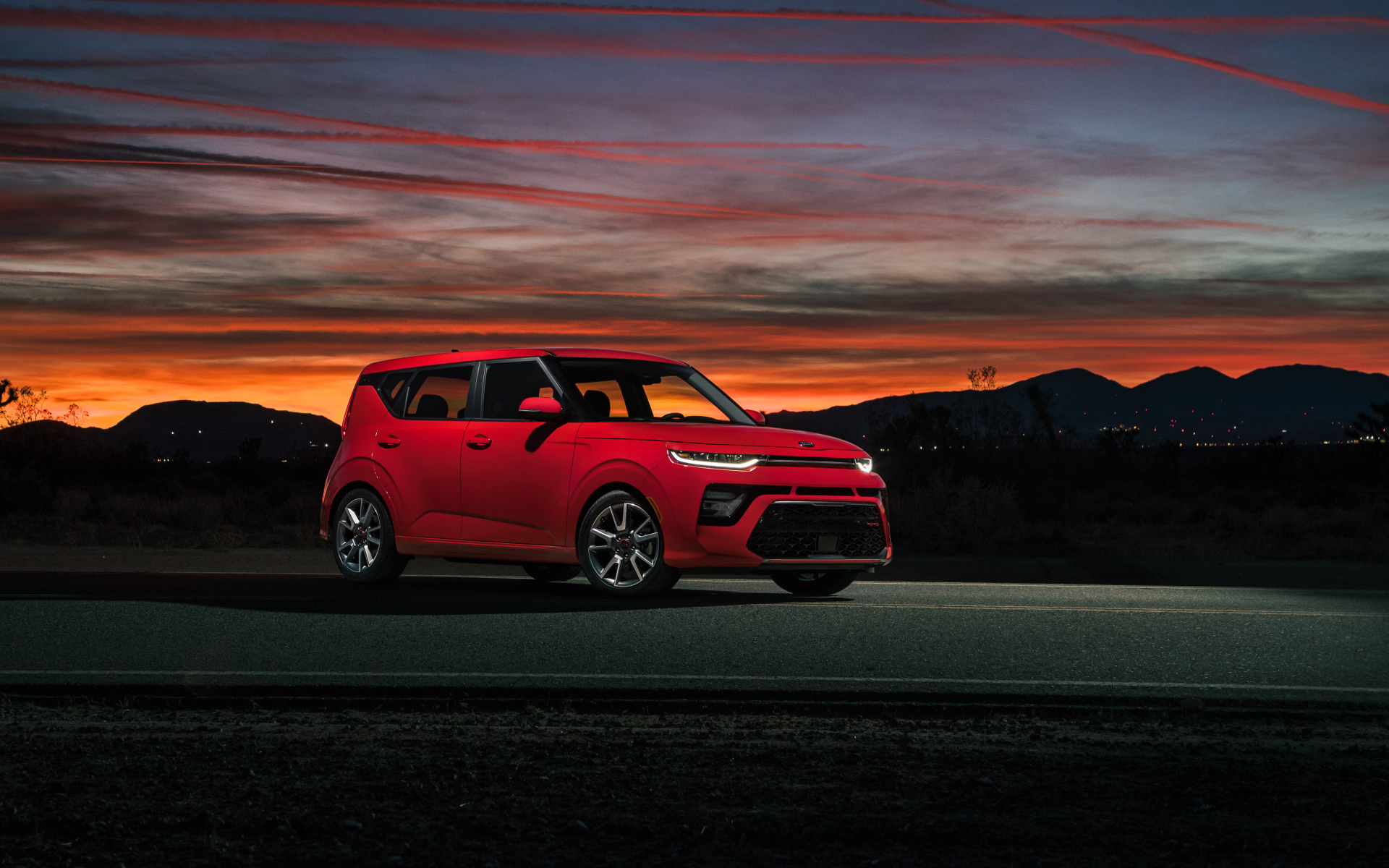 Красный автомобиль Kia Soul GT-Line, 2020 года на фоне ночного неба