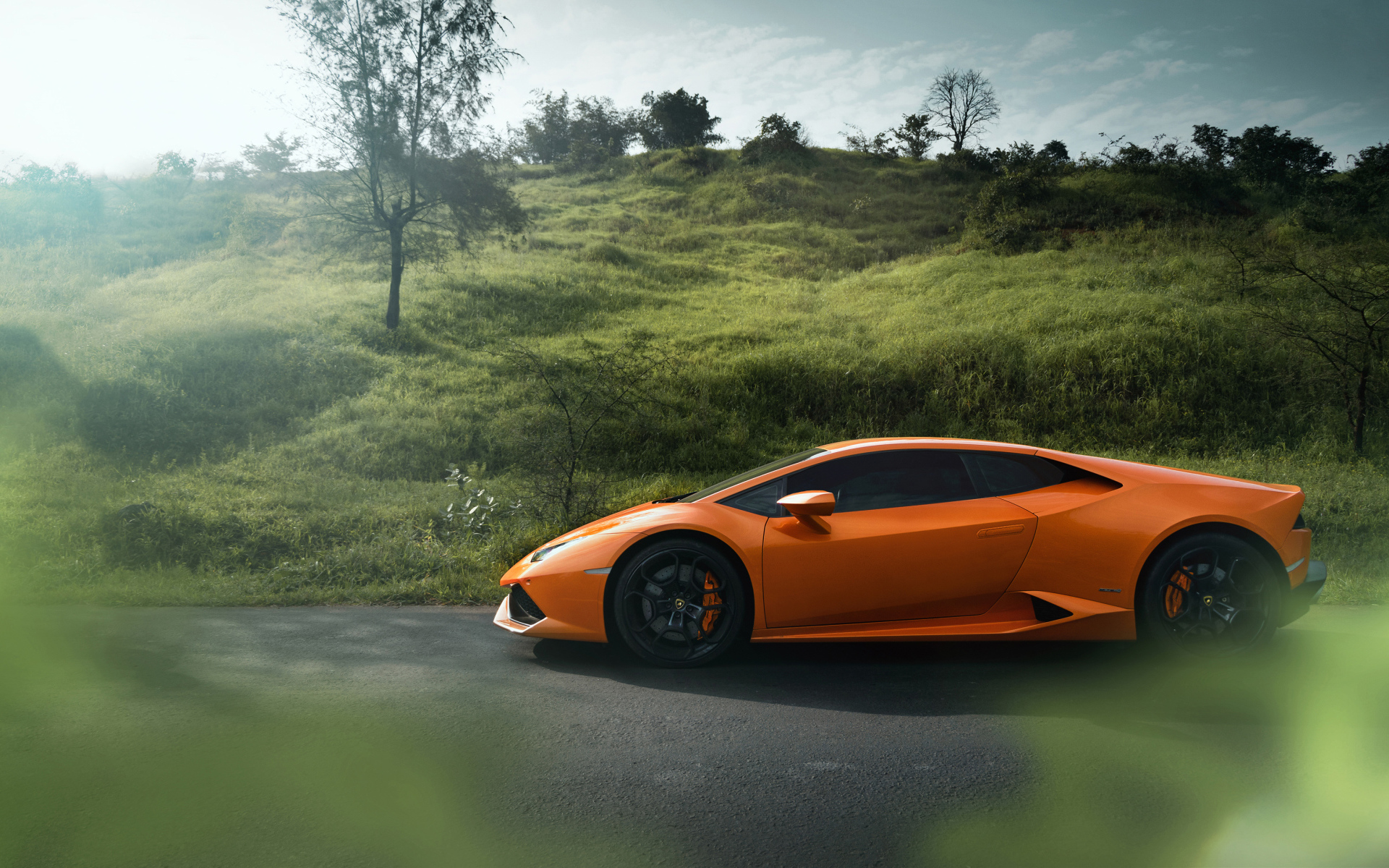 Оранжевый автомобиль Lamborghini Huracan 2019 вид сбоку