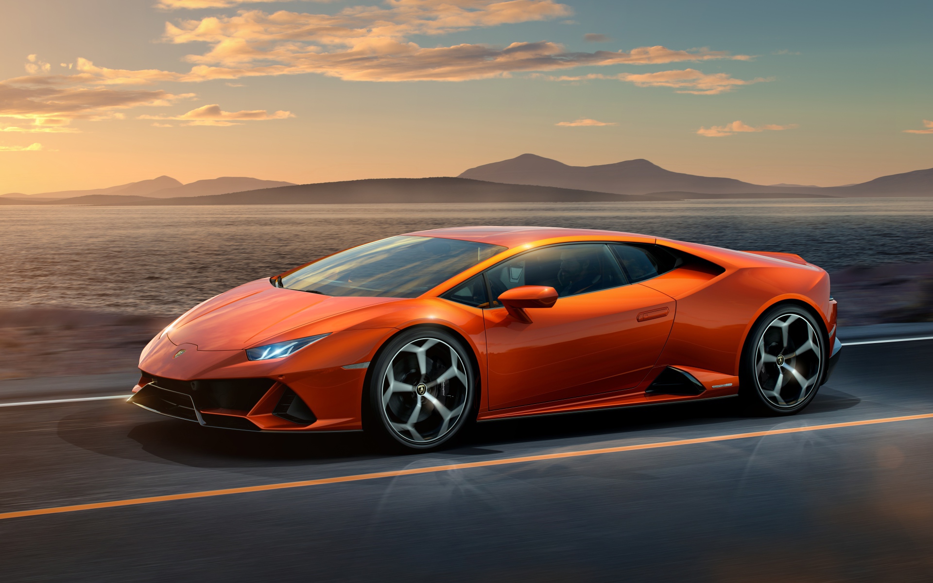 Оранжевый автомобиль Lamborghini Huracan EVO 2019 года на фоне неба 