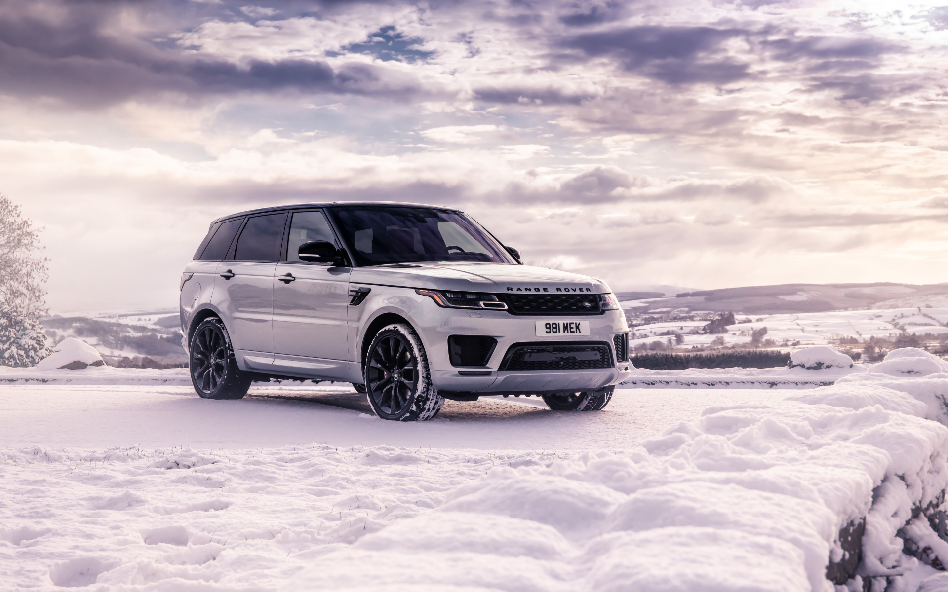 Серебристый внедорожник Range Rover Sport стоит на снегу