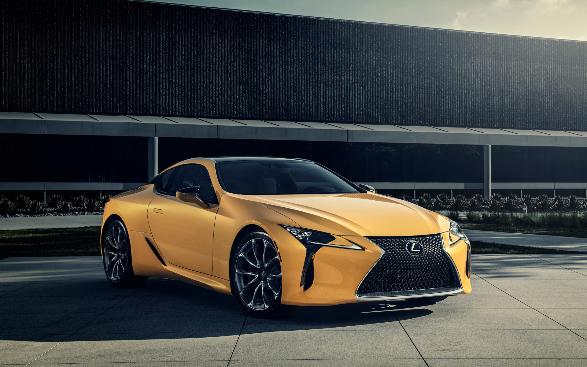 Желтый автомобиль Lexus LC 500 на фоне стены