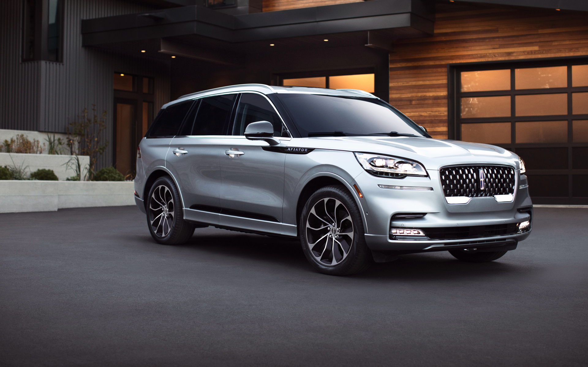 Серебристый внедорожник Lincoln Aviator Grand Touring, 2020 года на фоне дома