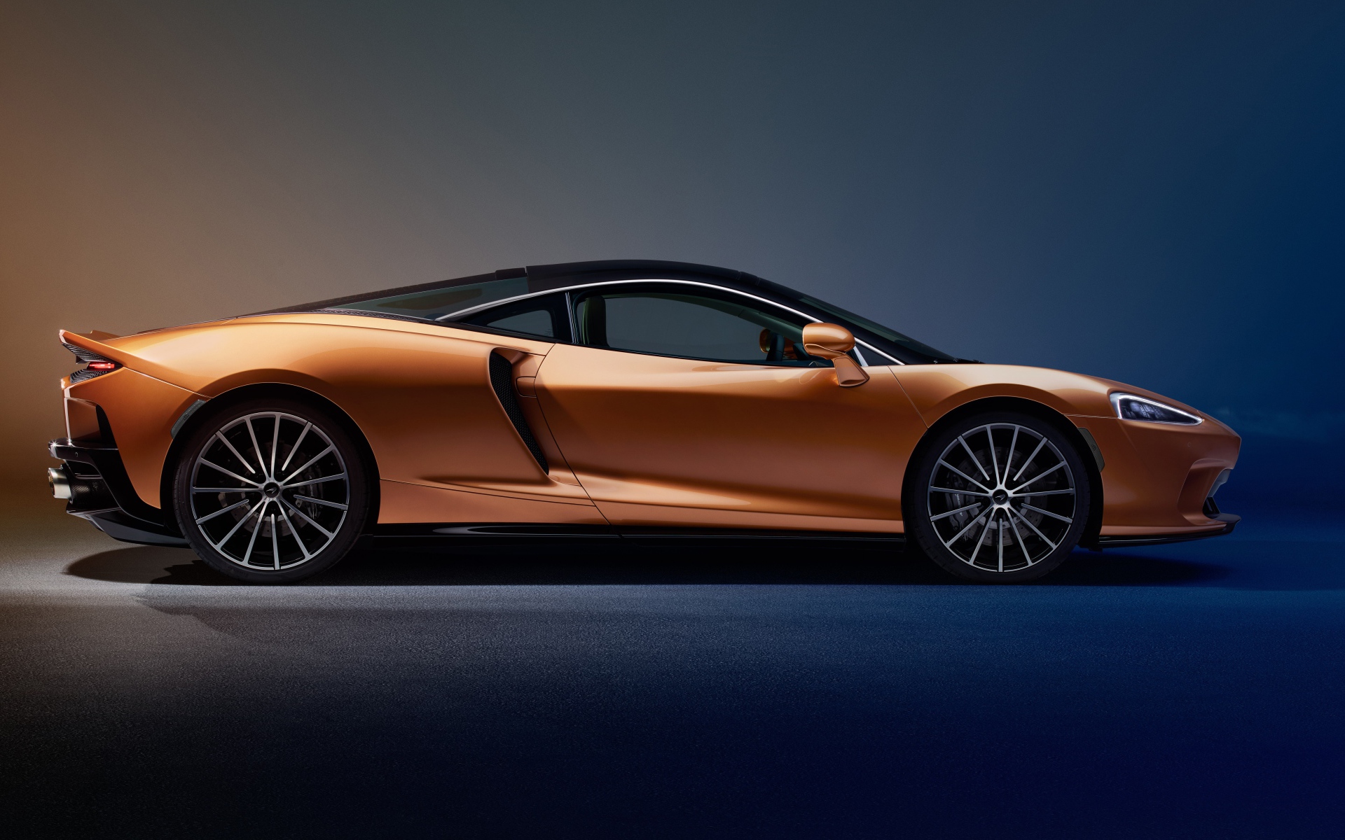 Оранжевый автомобиль McLaren GT Superlight 2019 года на синем фоне