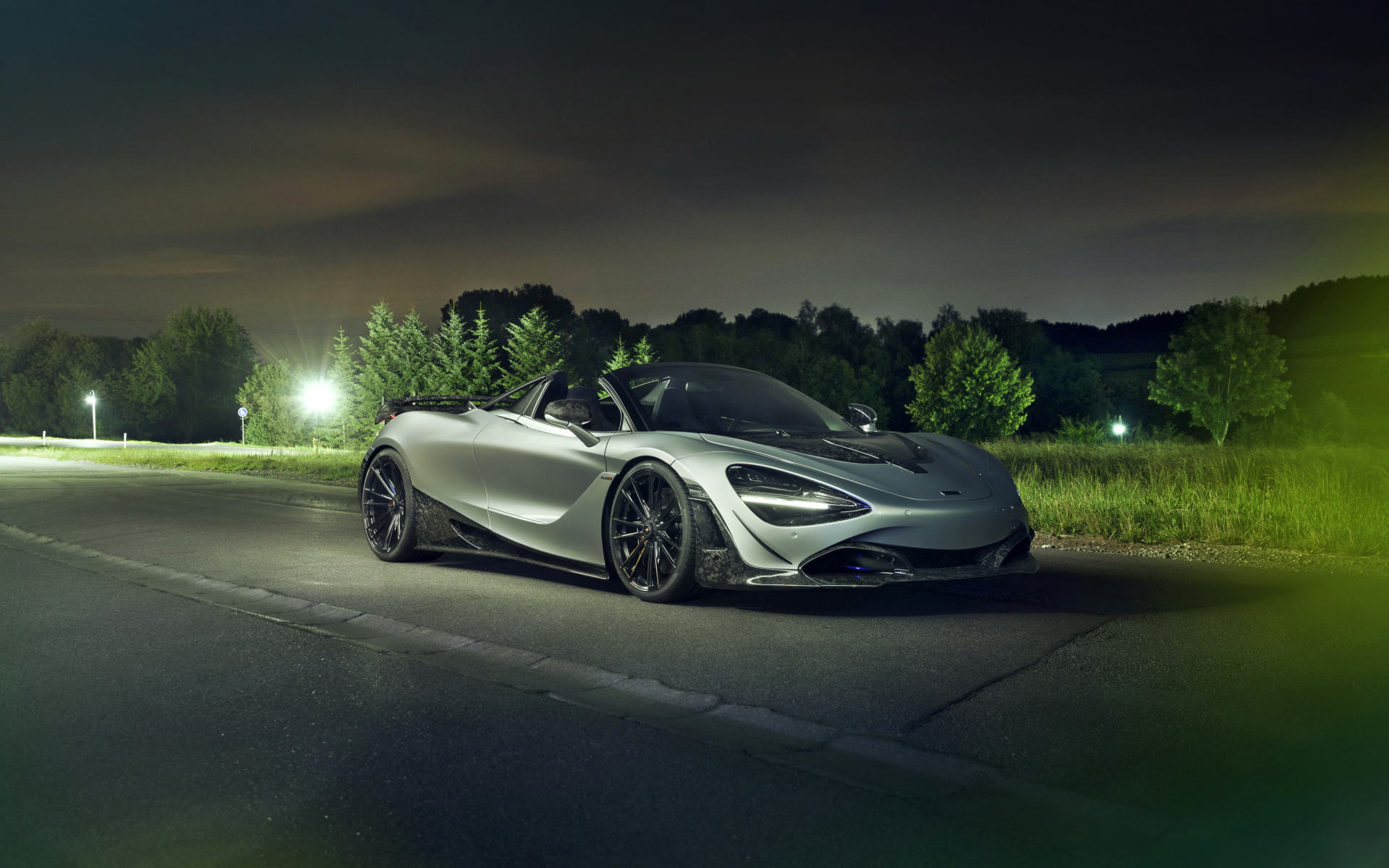 Серебристый автомобиль McLaren 720S Spider 2019 года ночью на дороге