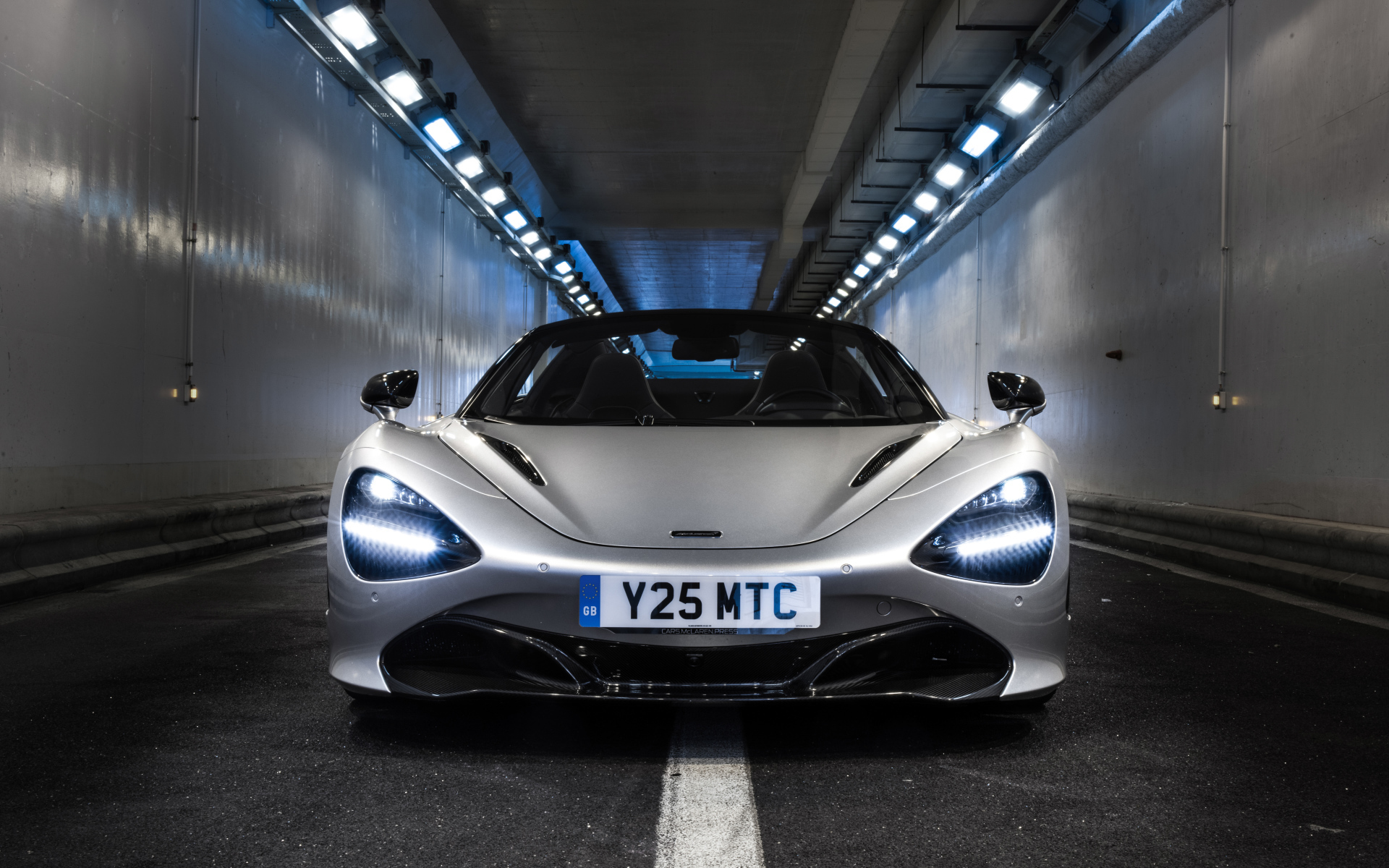 Серебристый спортивный автомобиль  McLaren 720S Spider, 2019 года в тоннеле