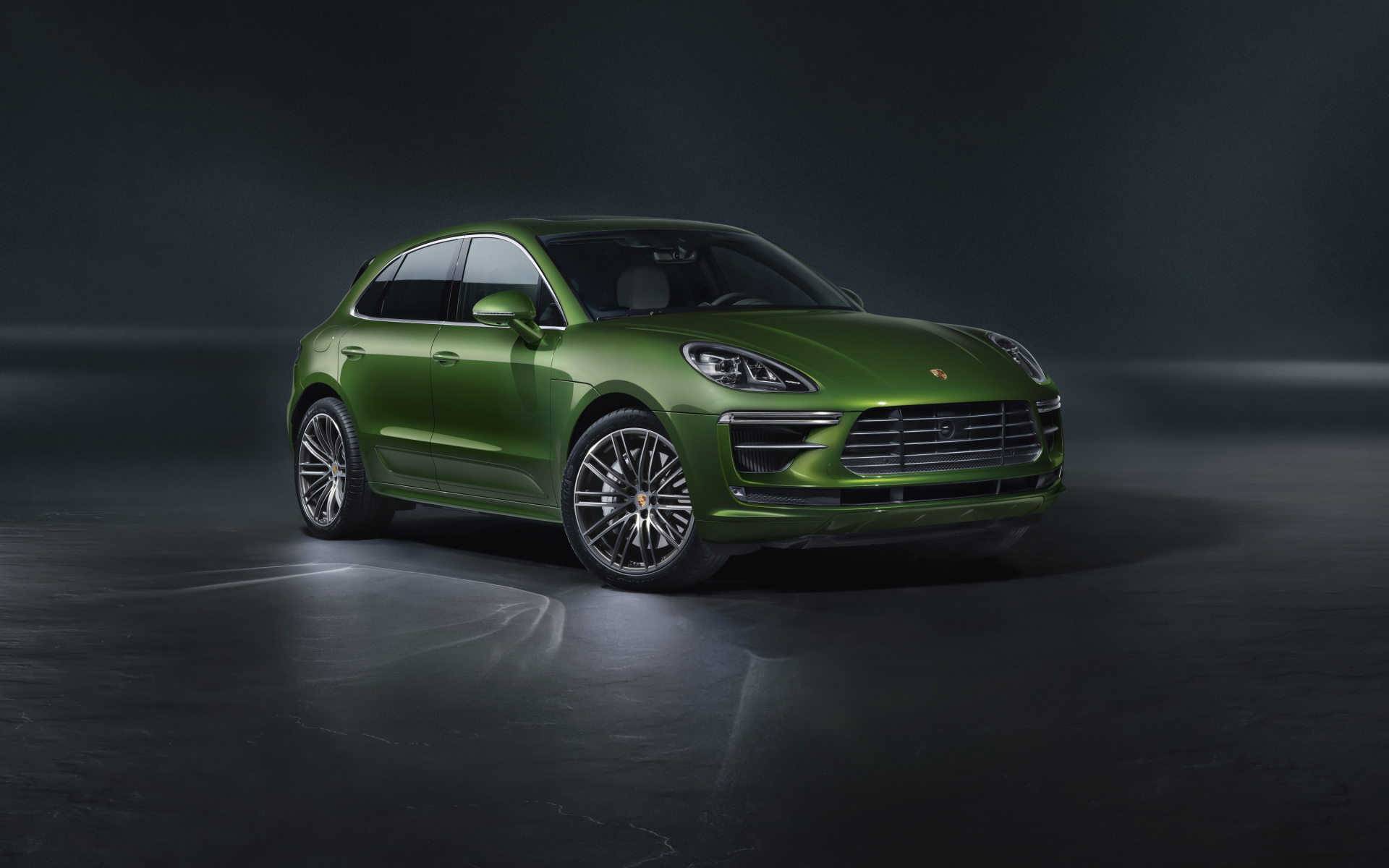 Зеленый автомобиль Porsche Macan Turbo 2019 года на сером фоне