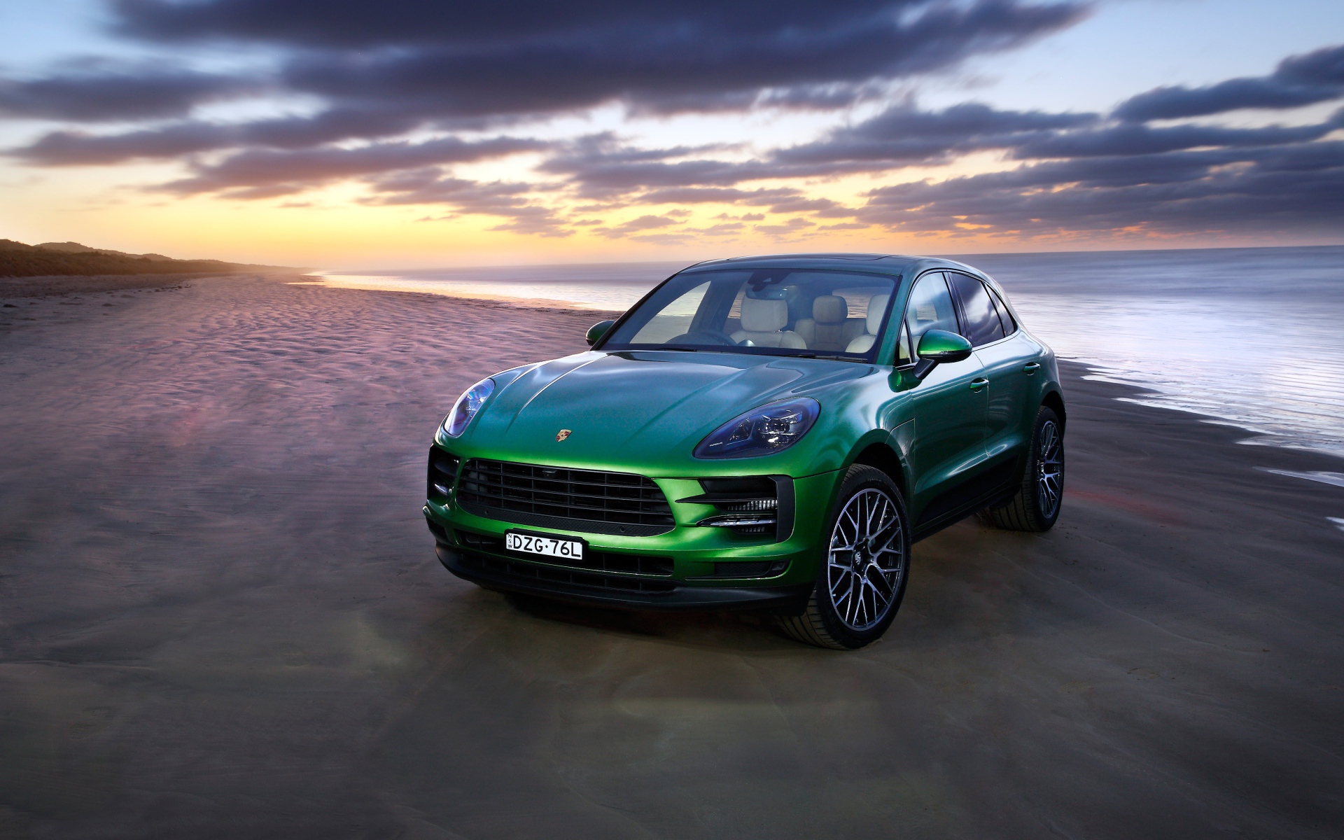Зеленый автомобиль Porsche Macan S 2019 года на берегу океана 