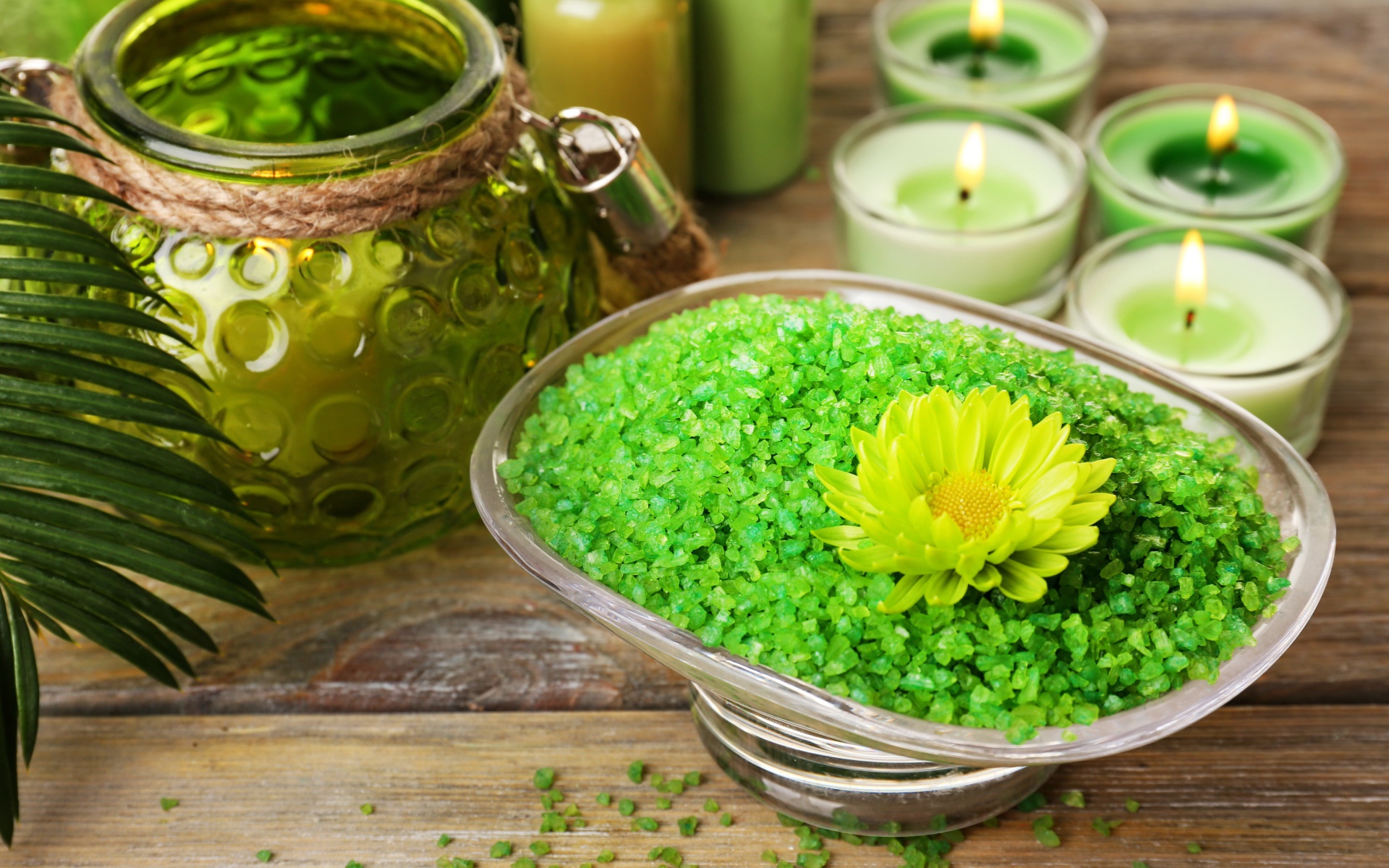 Зеленая ароматная морская соль на столе с зажженными свечами