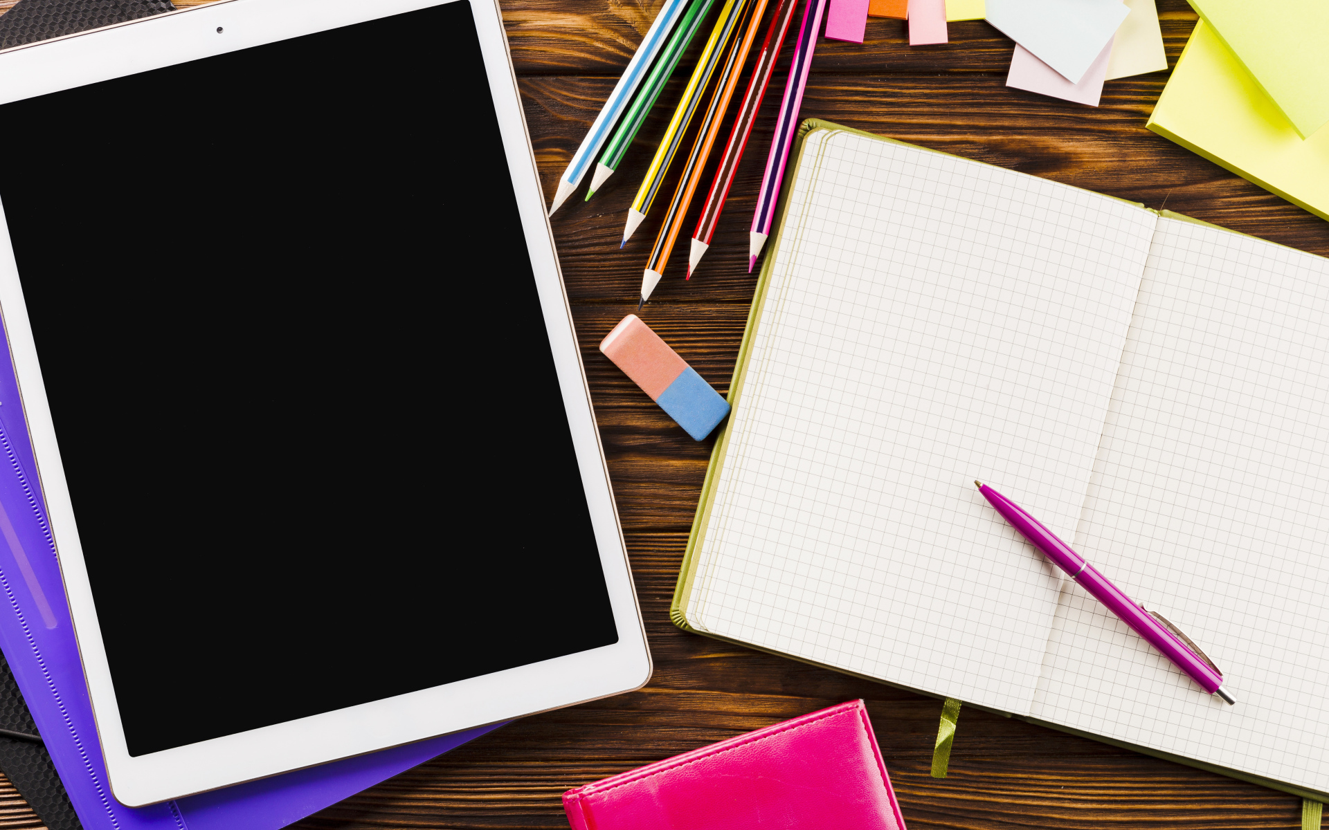 Планшет на столе с блокнотом и карандашами