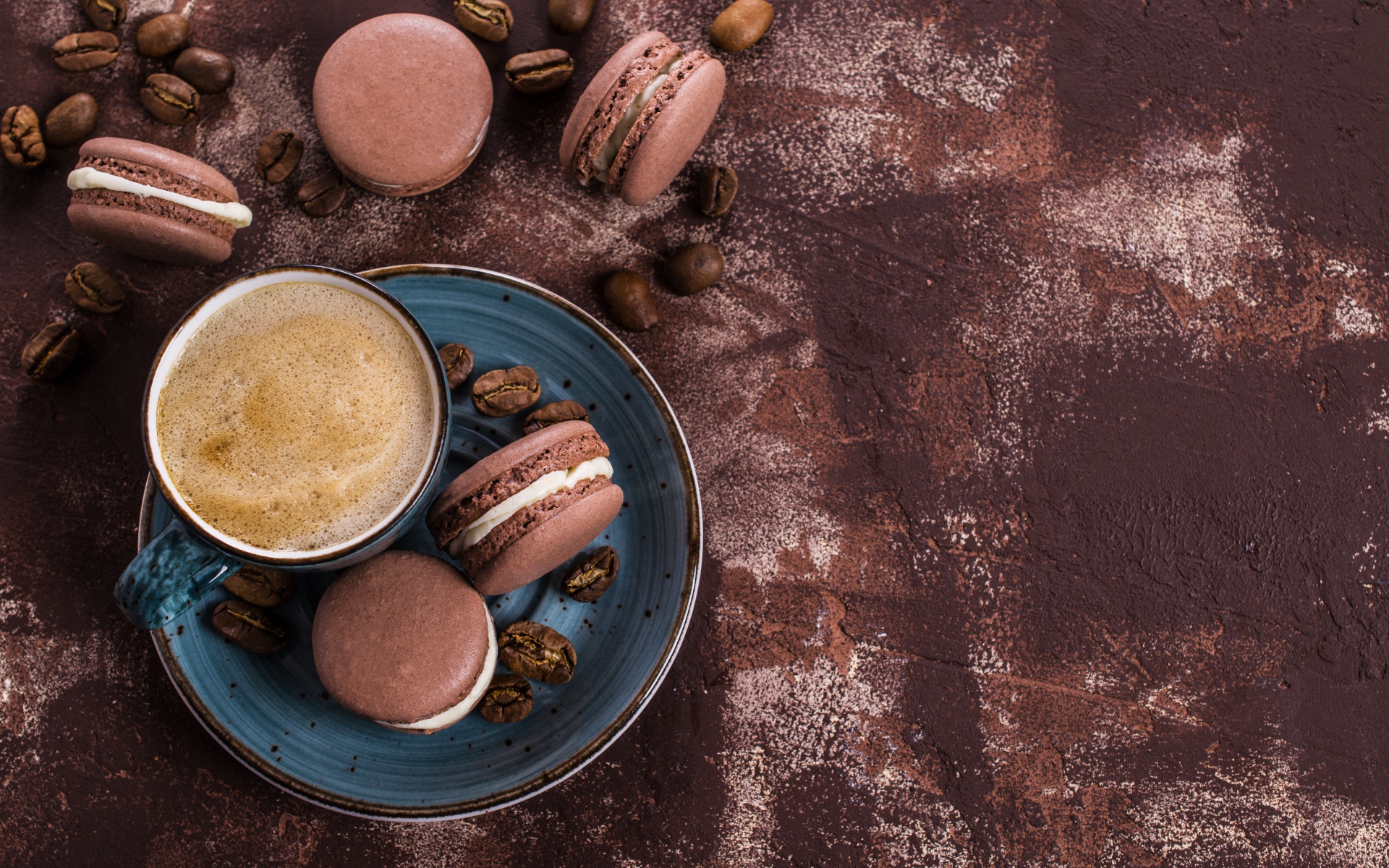 Чашка кофе с шоколадными макарунами на столе