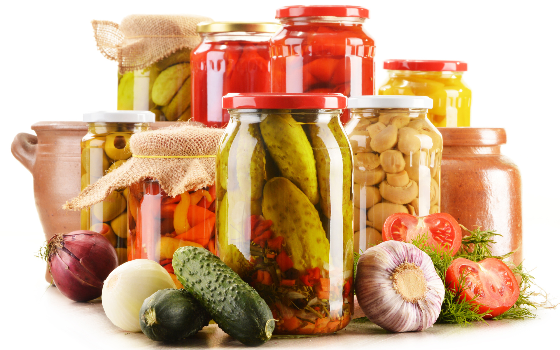 Консервация в банках на белом фоне с овощами