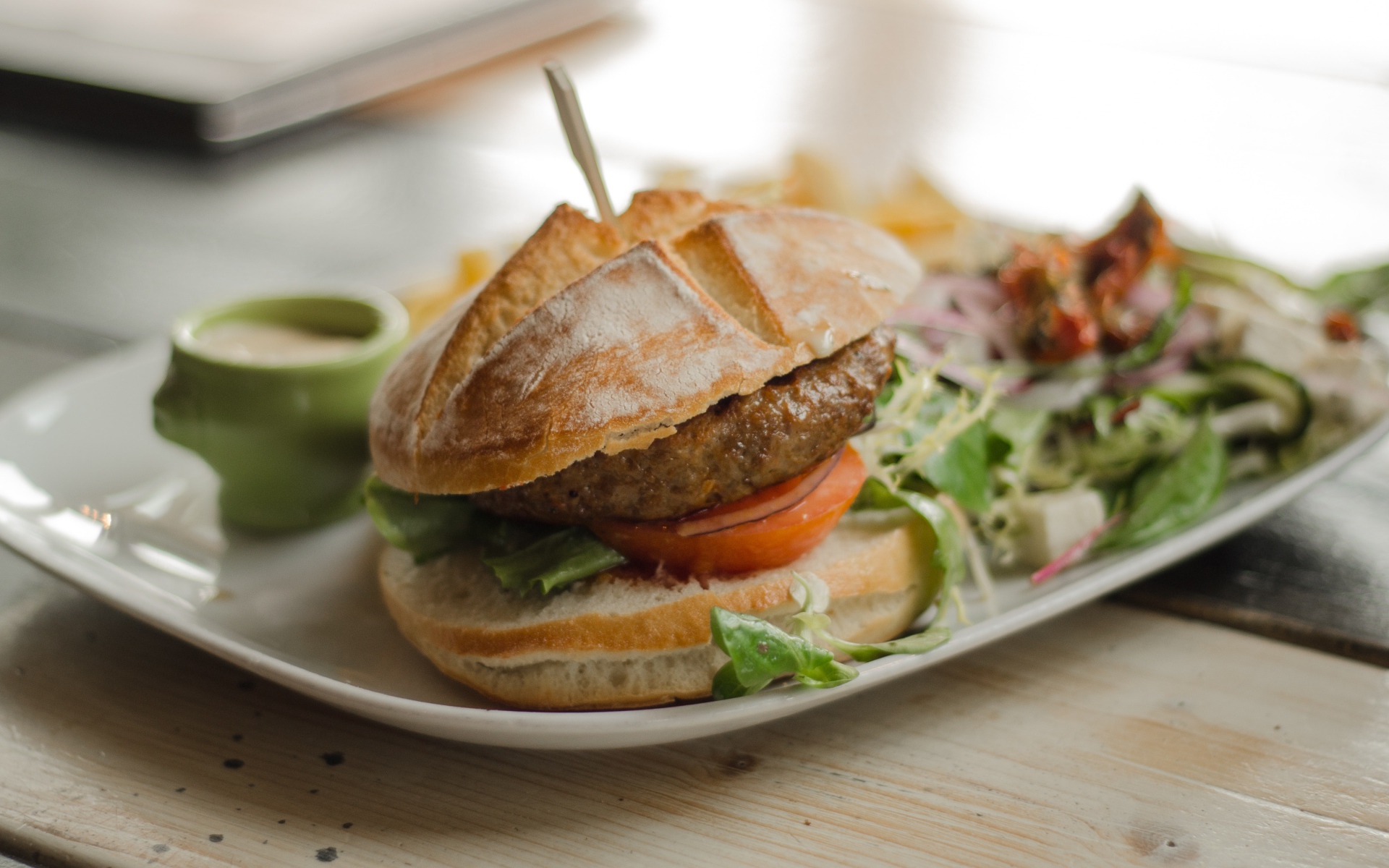 Гамбургер на тарелке с салатом 