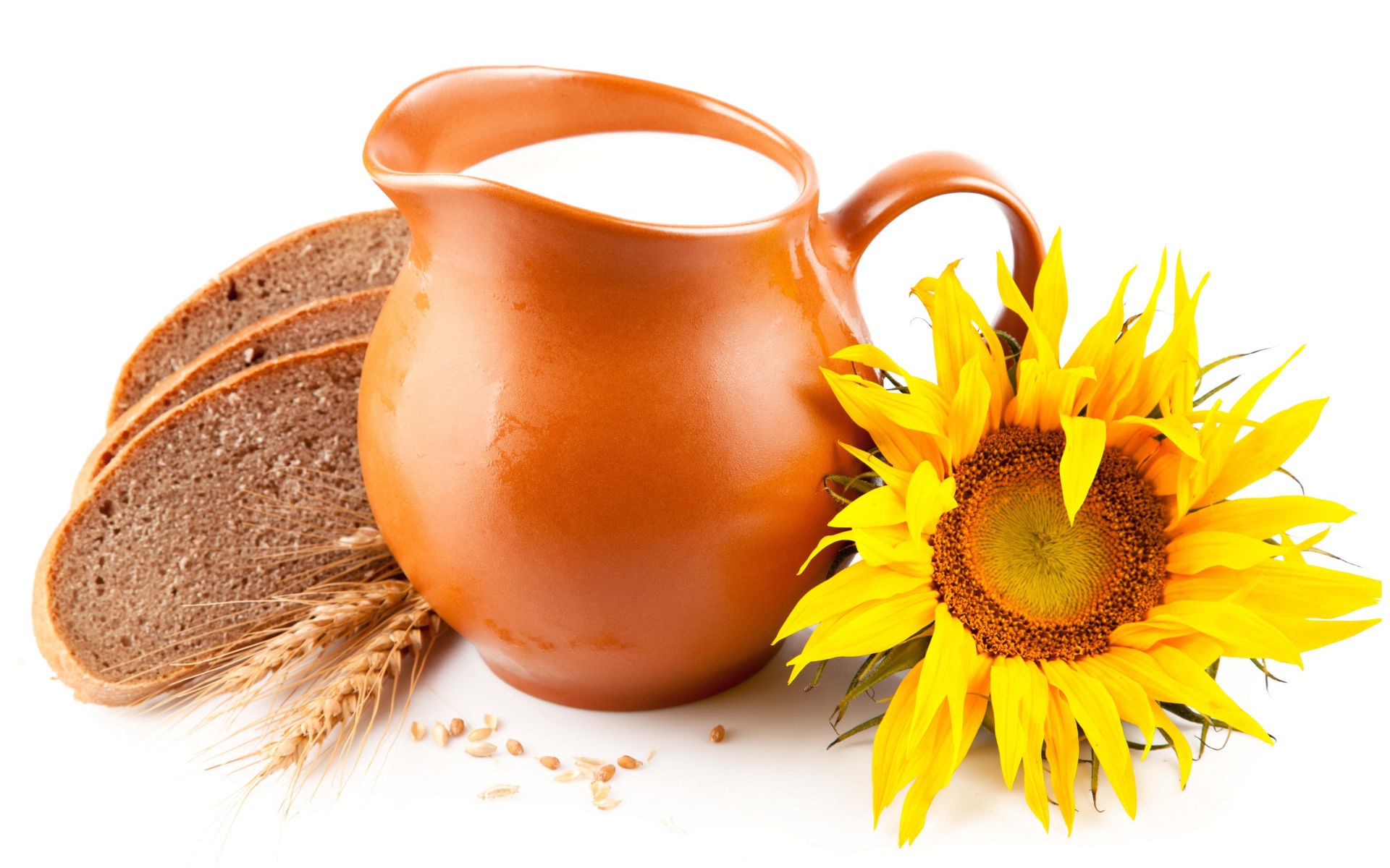 Кувшин с молоком на белом фоне с хлебом и подсолнухом