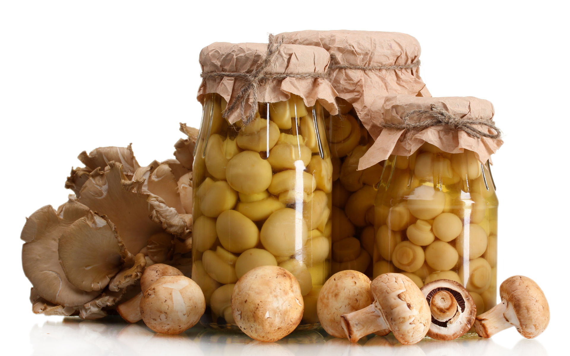 Маринованные шампиньоны в банках на белом фоне со свежими