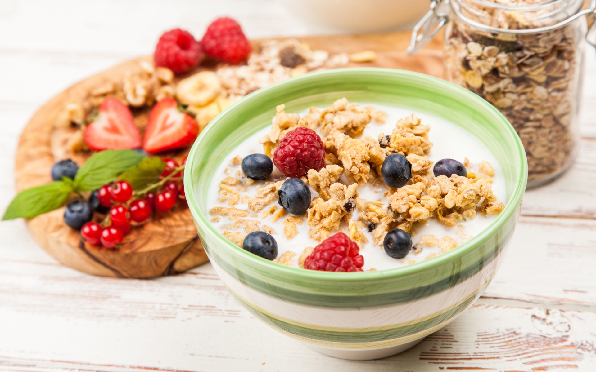 Мюсли с молоком и ягодами на столе к завтраку