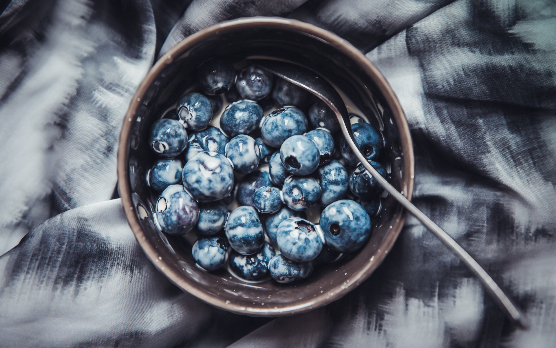 Черника в миске с йогуртом и ложкой