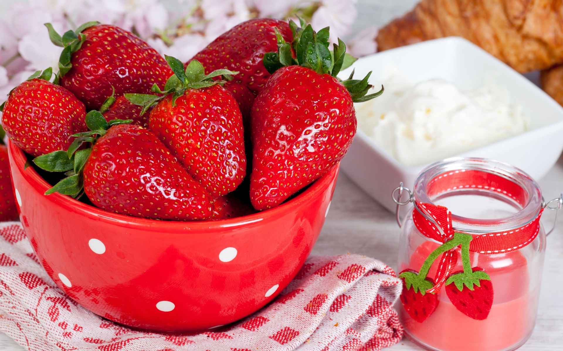 Свежие ягоды клубники в красной миске на столе