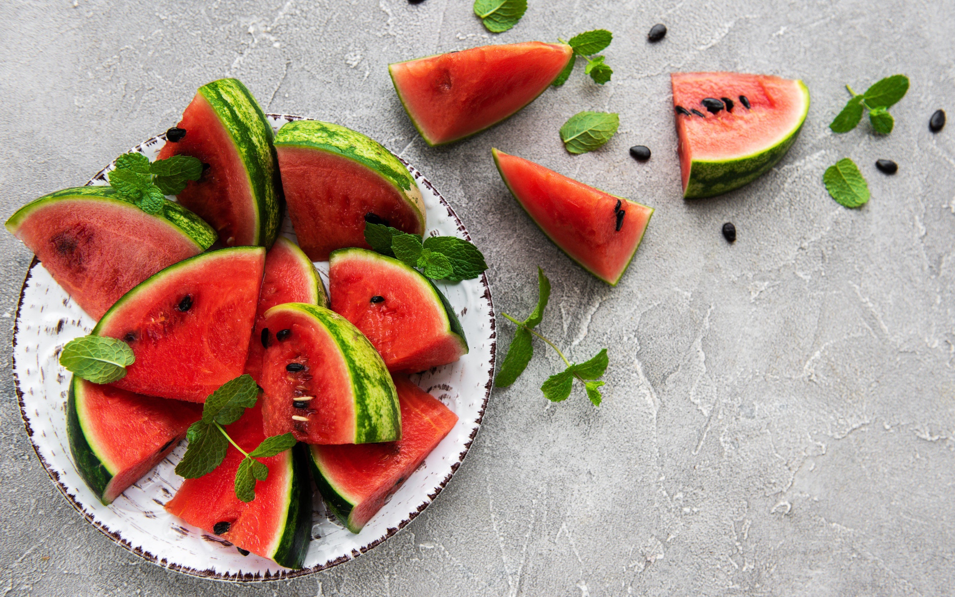 Полосатый арбуз нарезан кусочками на тарелке