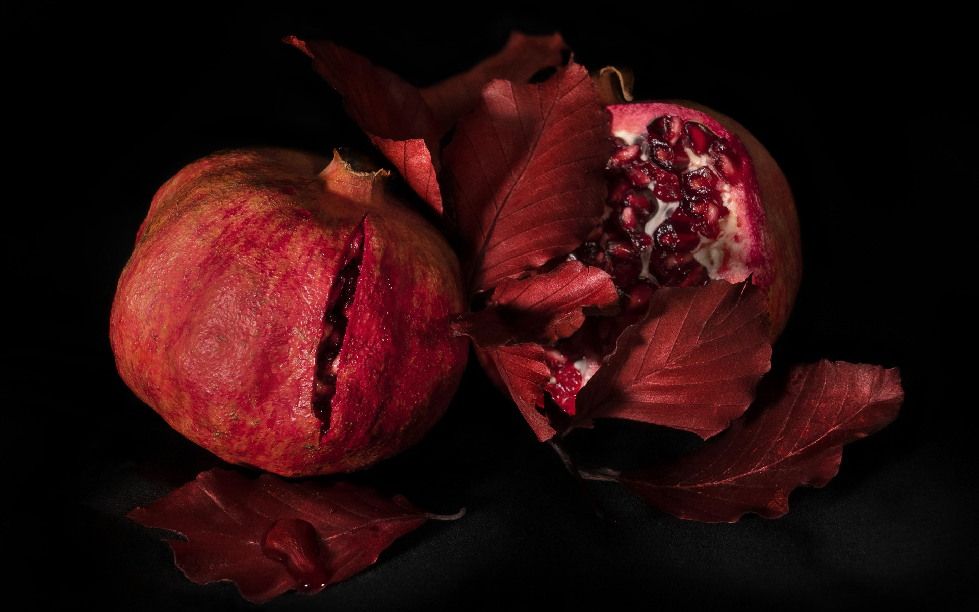 Два красных граната на черном фоне
