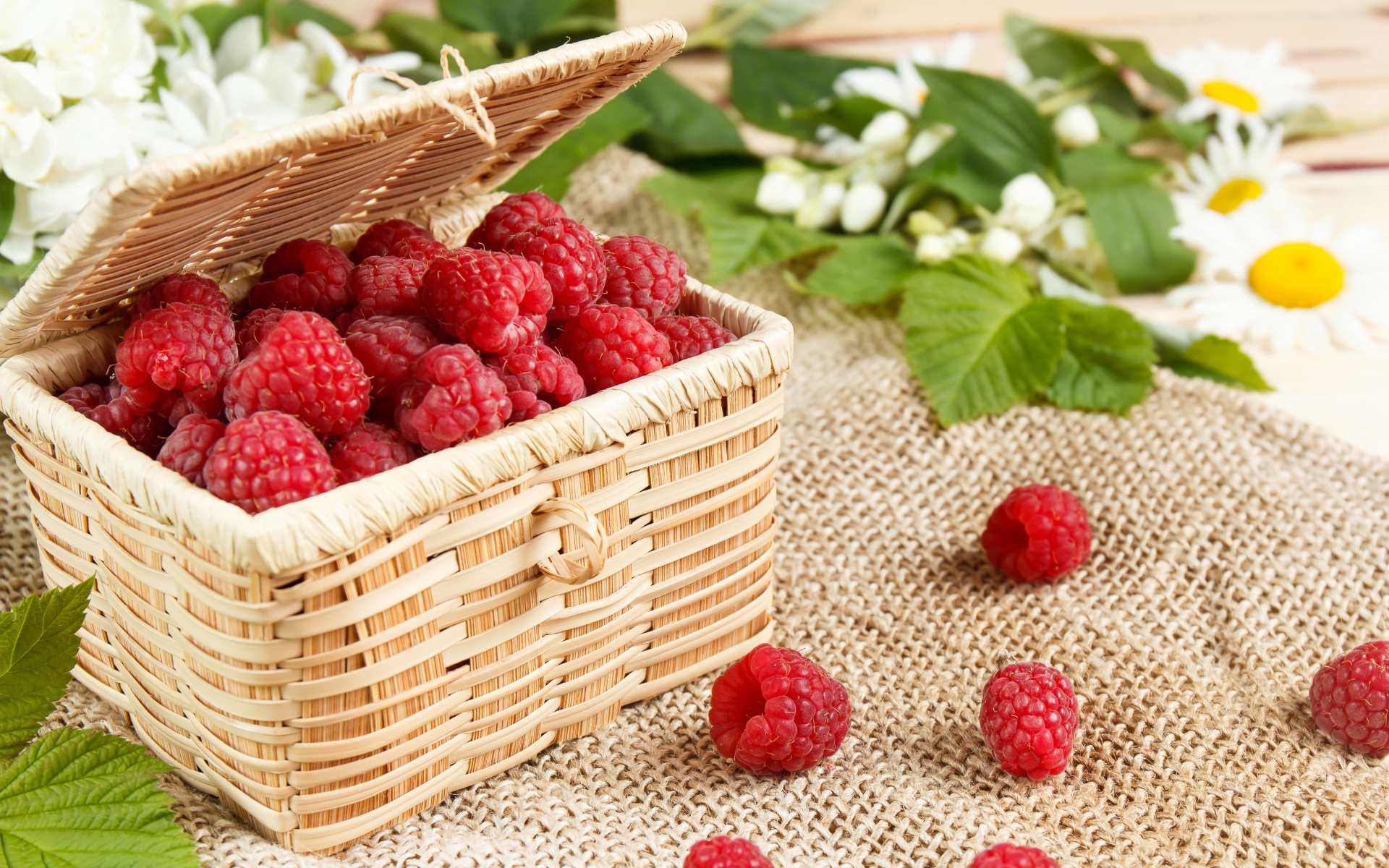 Плетеная корзина на столе с ягодами малины 