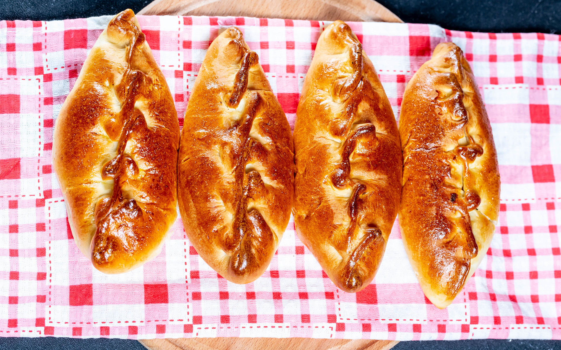 Аппетитные румяные пирожки лежат на полотенце 