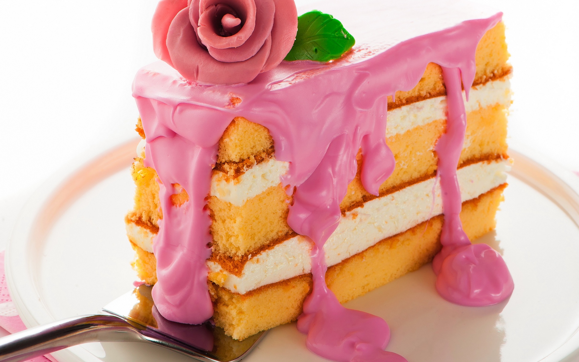Кусок торта с розовым кремом и сахарном розой