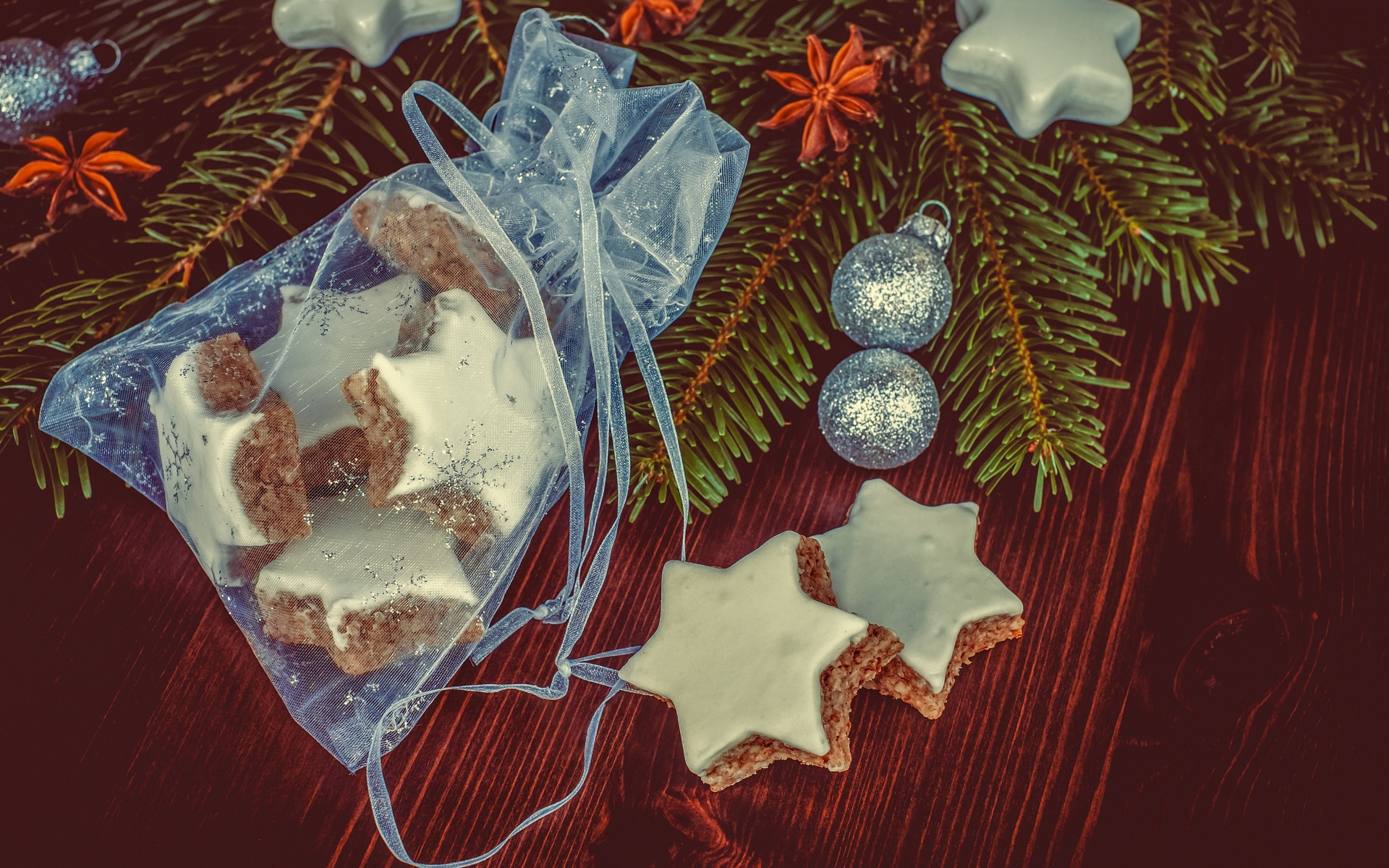 Аппетитное печенье звездочки в мешочке на столе с еловой веткой