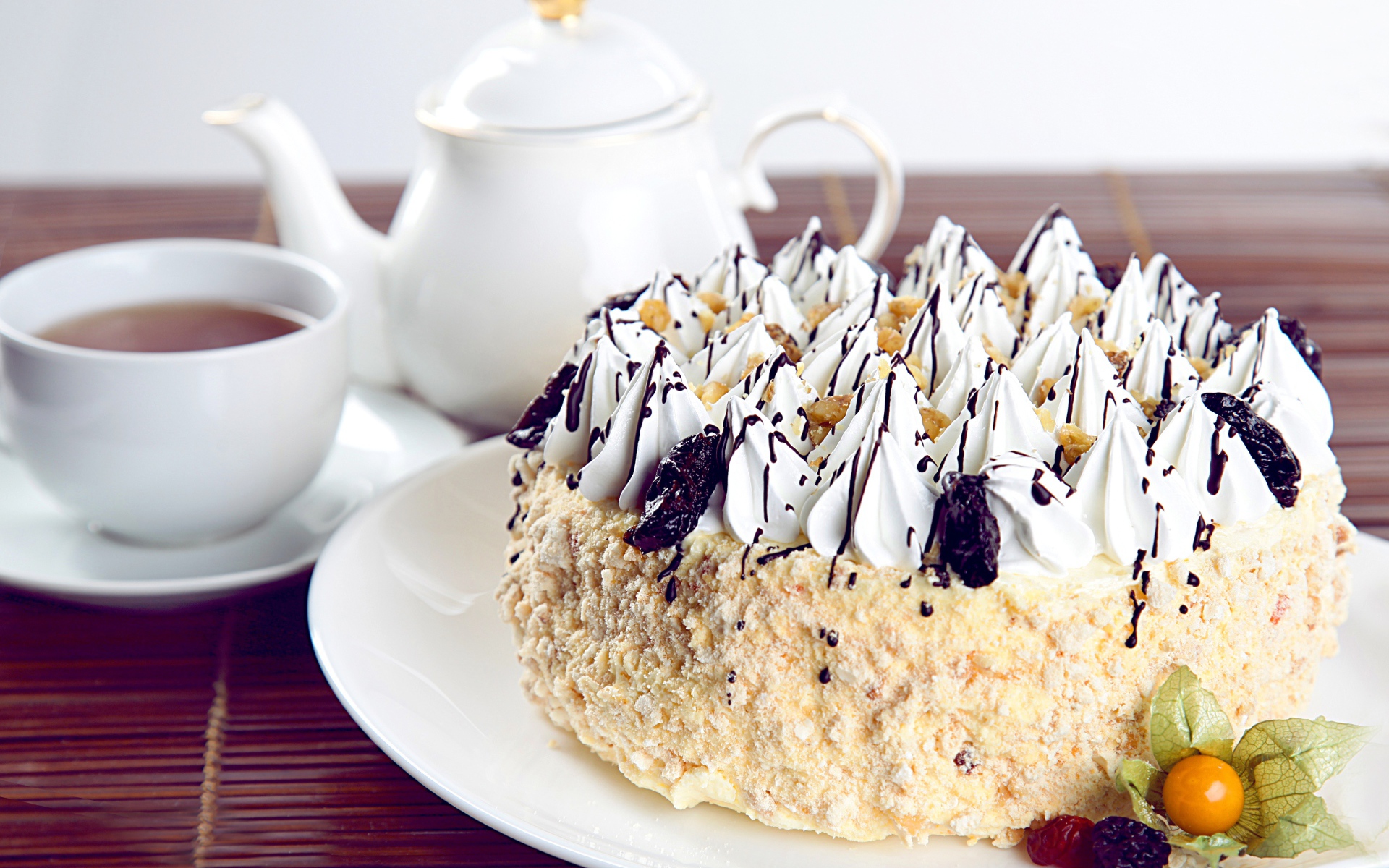 Красивый праздничный торт с безе на столе с чаем