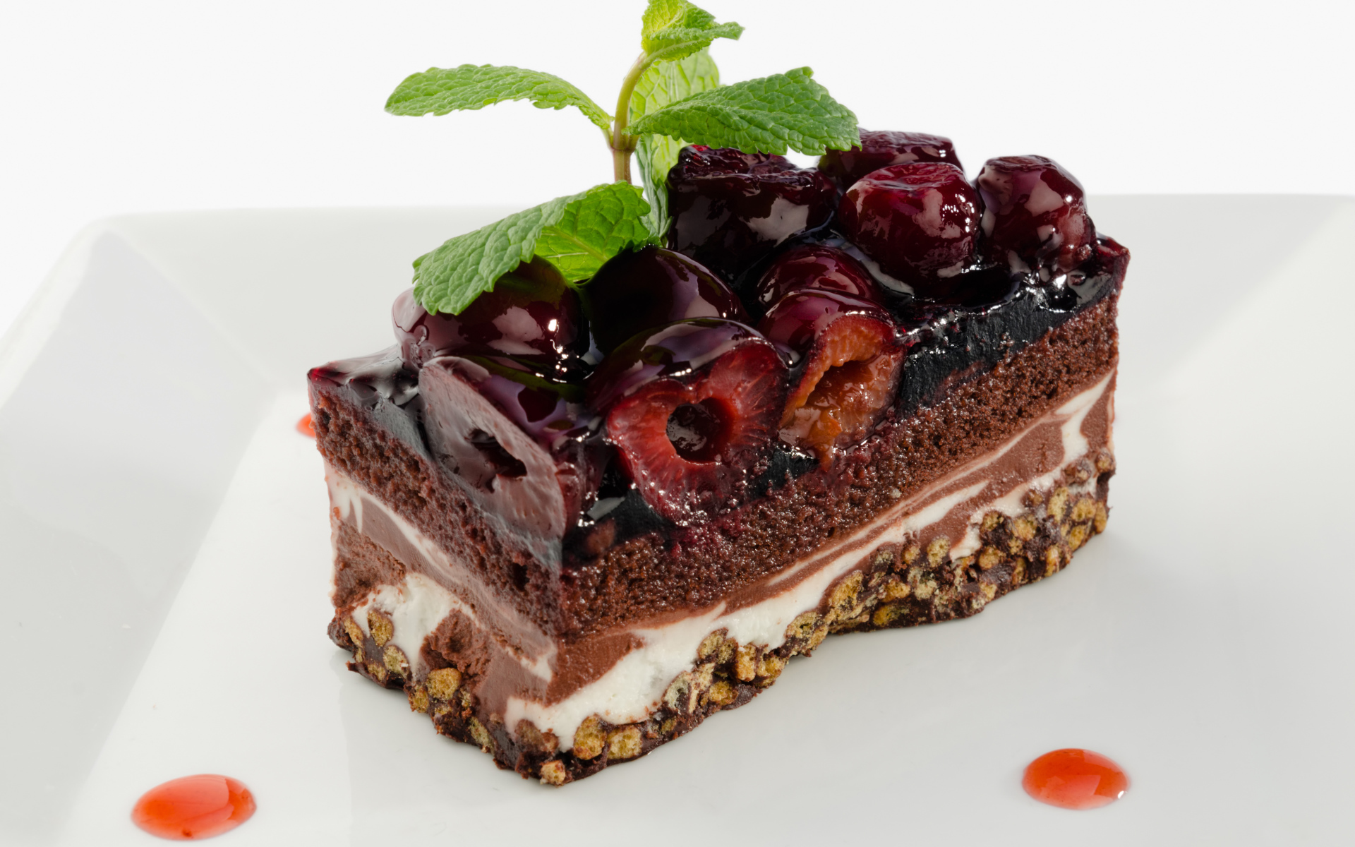 Пирожное с черешней и листиками мяты на сером фоне