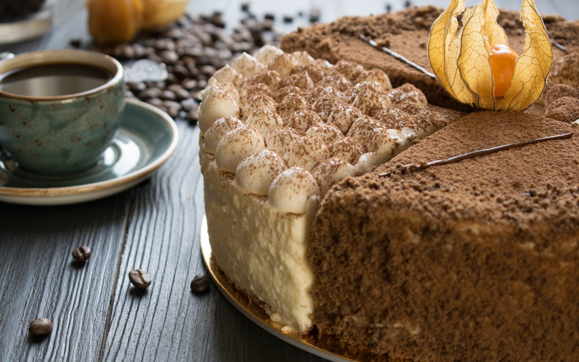 Вкусный торт с кремом и физалисом на столе с кофе