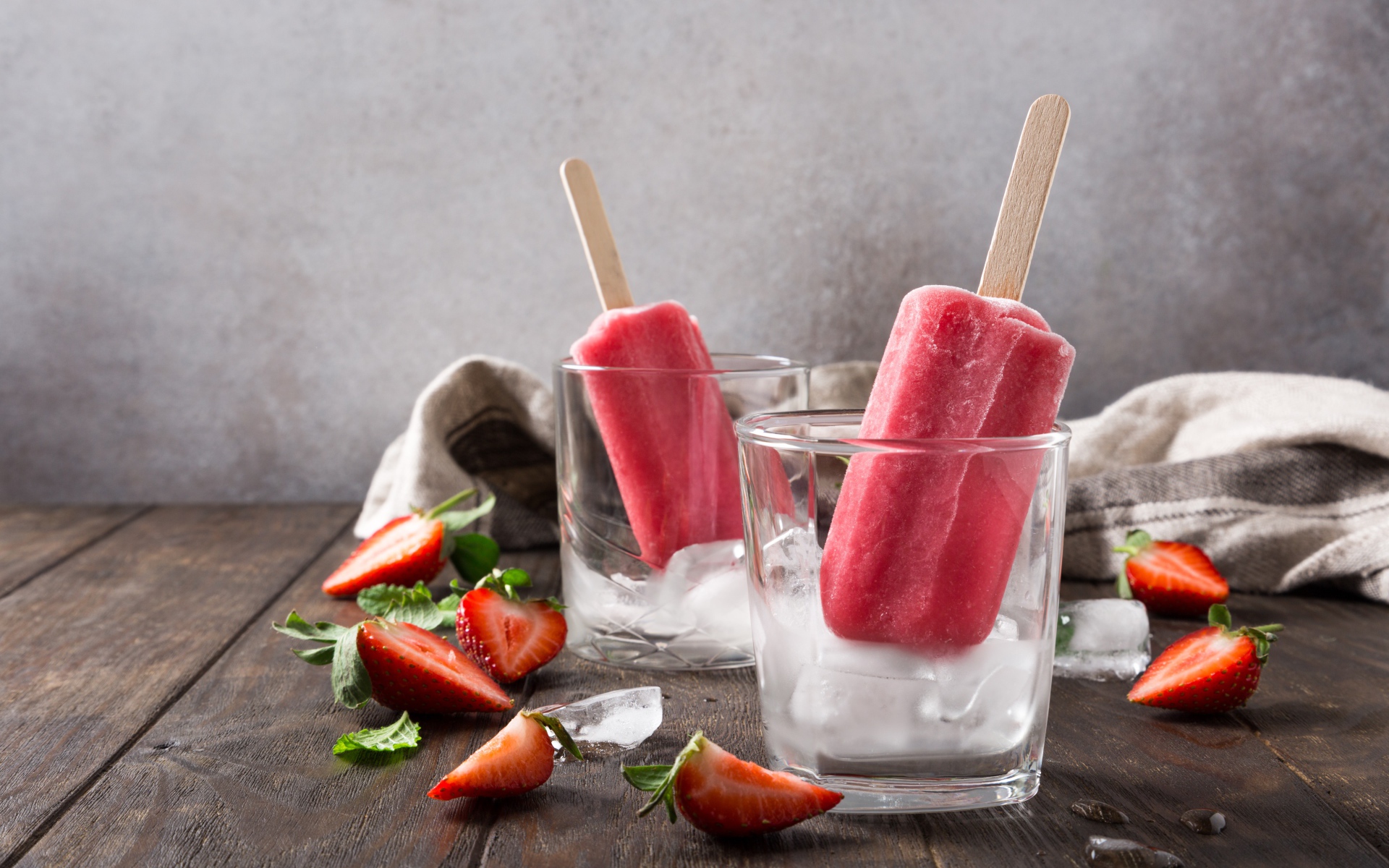 Фруктовое мороженое в стакане со льдом на столе с клубникой